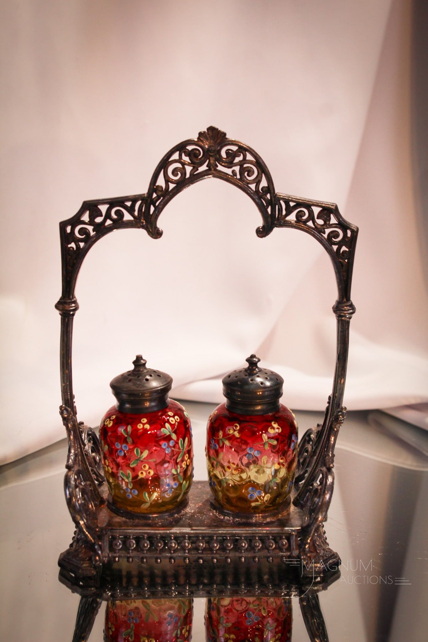 Amberina Enameled Victorian Silverplate Shaker Set: Intricate detailed enameling encompases the pair of wonderful amberina colored shakers set in silverplate holder. Holder is signed Ashberry & Sons, Sheffield. Measures 8 1/4" tall.