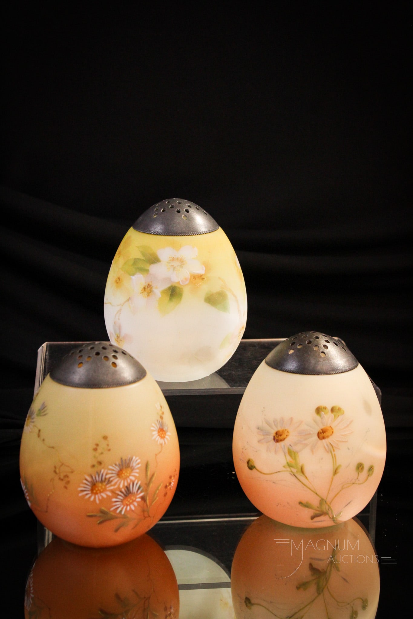 3 pc Lot Happy Family Mt. Washington Egg Sugar Shakers: Three wonderful examples of Mt. Washington Victorian glass egg form sugar shakers in various floral decorations. Each measures 4" tall.