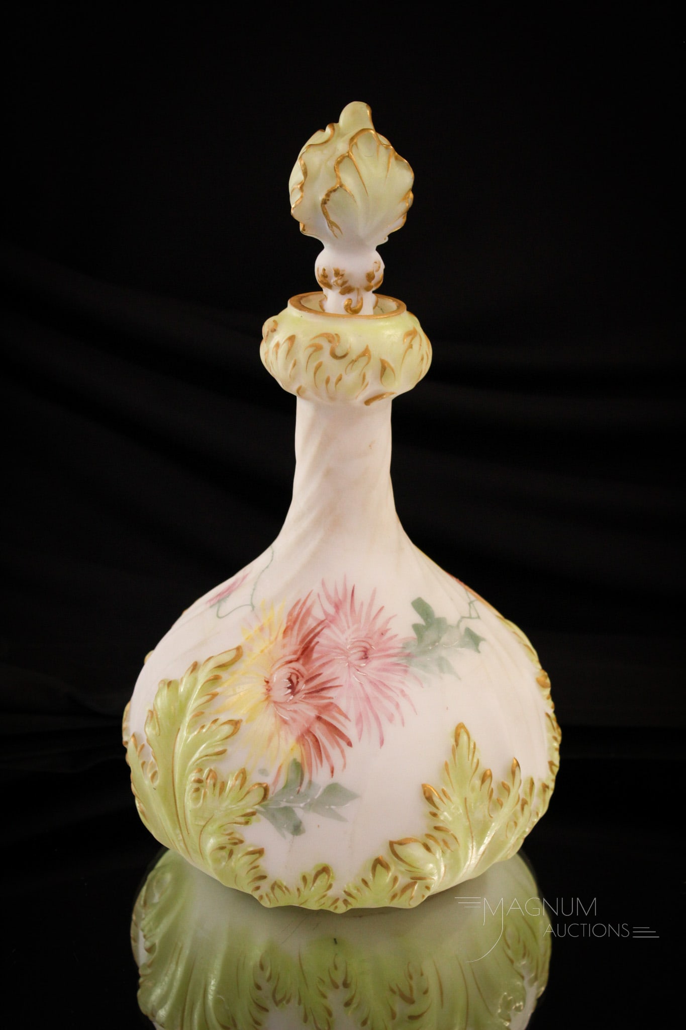 Mt. Washington Pairpoint Victorian Glass Cologne Dresser Bottle: Fine example of a Mt. Washington Pairpoint decorated dresser or cologne bottle with green decoration, completed by the matching stopper. It measures 9 1/2" tall.