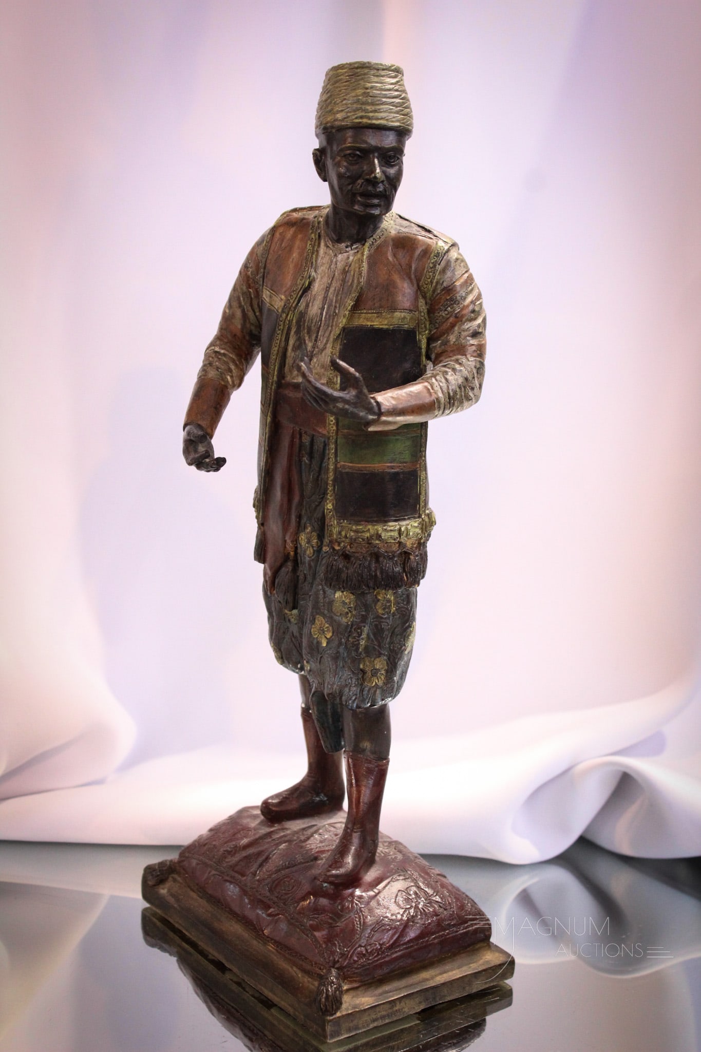 Cold Painted Vienna Bronze Middle eastern Male Figure: Interesting, and yet, cold painted Vienna bronze of a middle eastern man standing atop an extra firm pillow. Measures 12 1/2" tall.