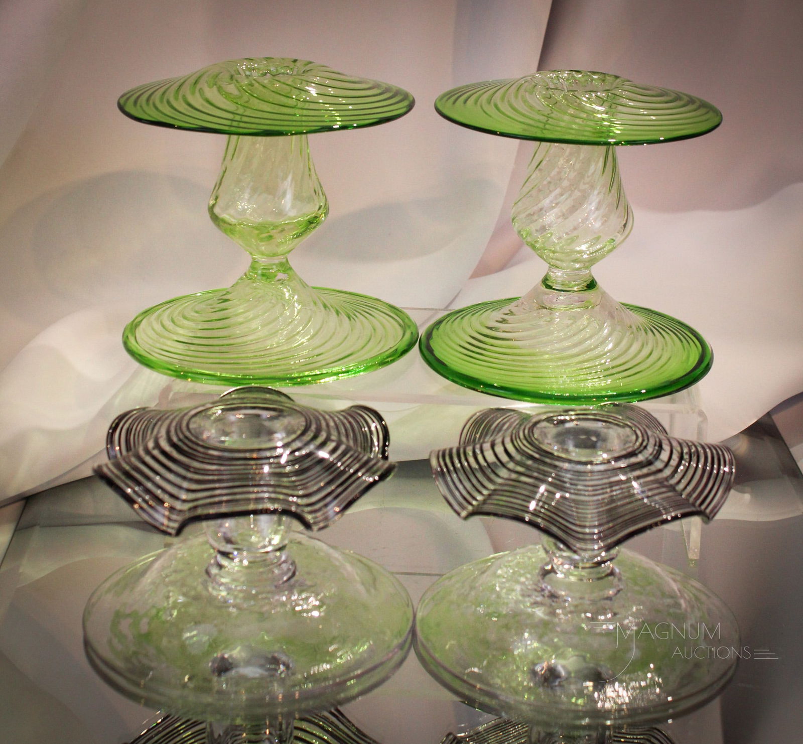 2 Pair lot Steuben Glass Candlesticks: Two fine pairs of Steuben glass candlesticks offered in this lot. One pair in green and clear swirl. The other clear with black threading. Tallest measures 4".