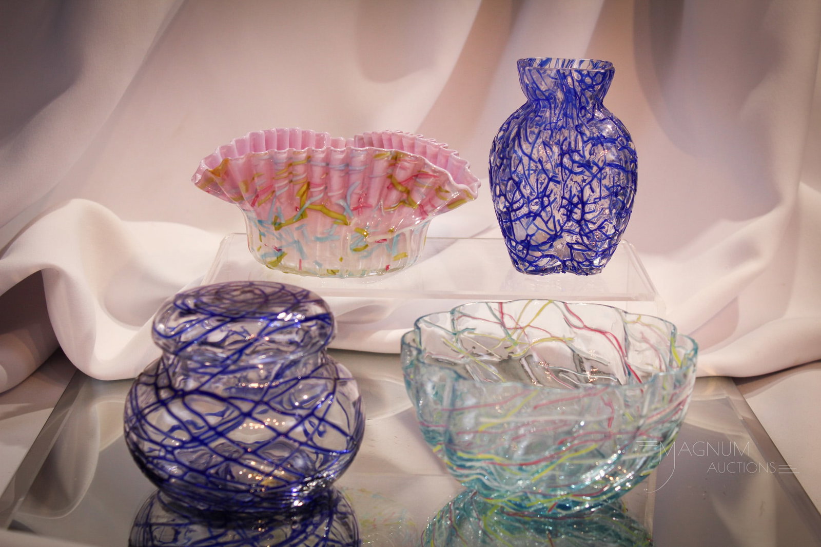 4 pc Lot Peloton & More Glass: Nice assembly of peloton and threaded decorated glass. Lot is comprised of a clear lobed cabinet vase decorated with blue threading, a triangular cased rainbow peloton bowl, a blue threaded covered ja