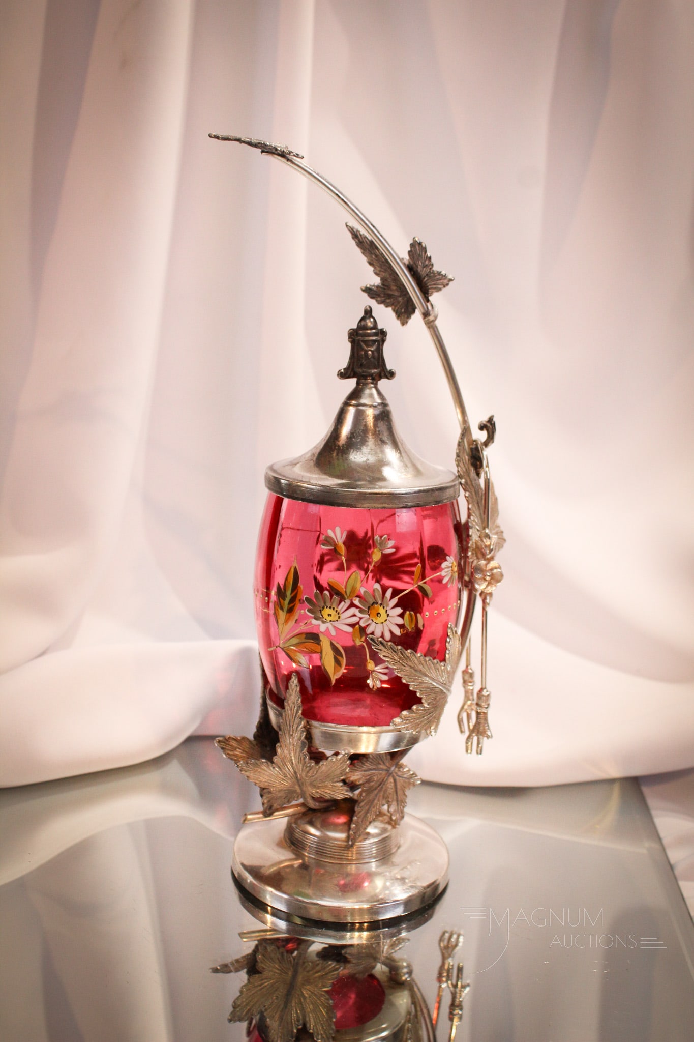 Rogers Silverplate Cranberry Enameled Glass Victorian Pickle Castor: Select offering of a fine leaf adorned Victorian pickle castor. Frame is signed Rogers silverplate. Jar is cranberry gilt and enamel decorated. Great piece measuring 12" tall.