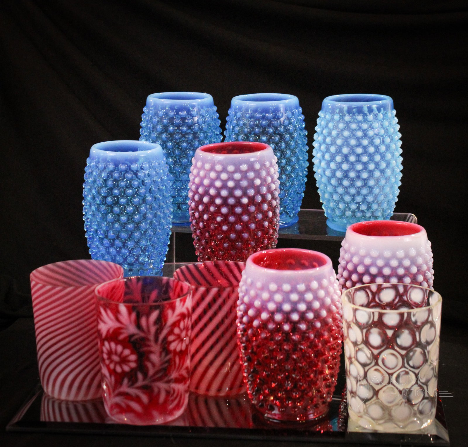 11 pc Lot Fenton & More Opalescent Glass Tumblers: Generous offering of an 11 piece lot of Fenton Tumblers along with others. Four blue opal hobnail examples. Three cranberry opal hobnail. Four are examples of L. G. Wright tumblers. Tallest measures 5