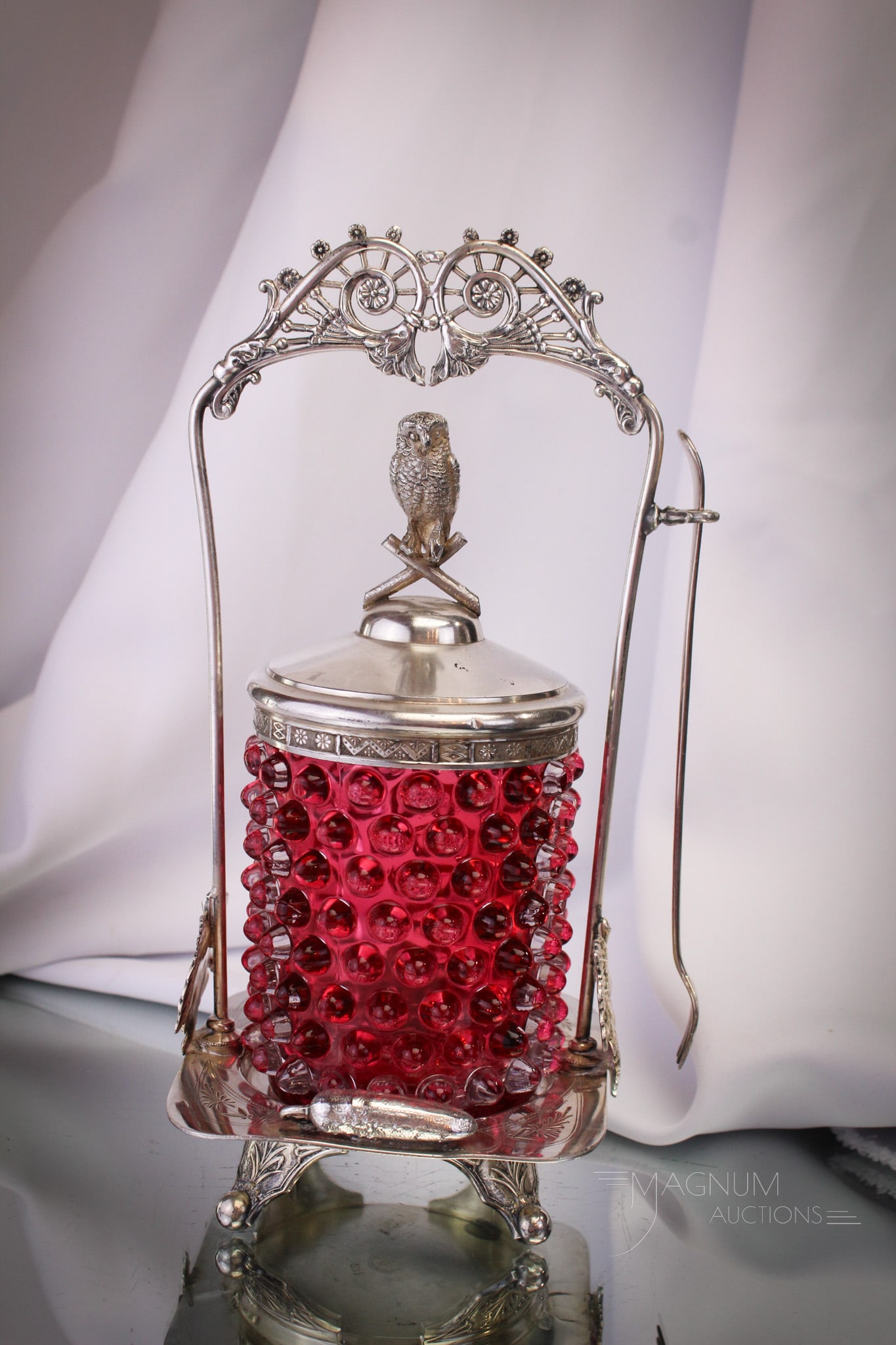 Derby Silverplate Figural Owl & Pickles Cranberry Pickle Castor: Charming as it gets folks! This lovely pickle castor is made by Derby Silverplate and is adorned by everyone's fan-favorite gerkin. The jar is a cranberry hobnail pattern glass. It features a figural 