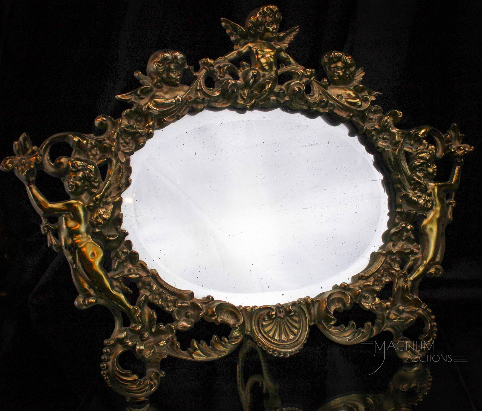 Victorian Cast Metal Bronze Chrubium Dresser Mirror: Wonderful cast metal with a bronze finish Victorian dresser or petticoat mirror. Mirror is decorated with cherubim motif. Mirror measures 13" tall, 18" long. Nice Size! Beautiful example.