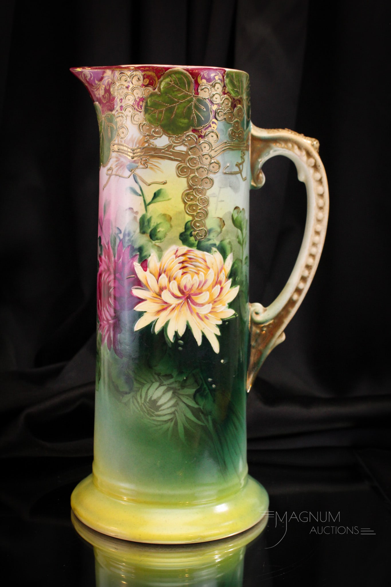 Nippon Porcelain Chrysanthemum Decorated Tankard Pitcher: Elaborately decorated Nippon porcelain tankard pitcher. Piece is elaborately adorned with chrysanthemum decoration. Pitcher measures 12 1/2" tall.