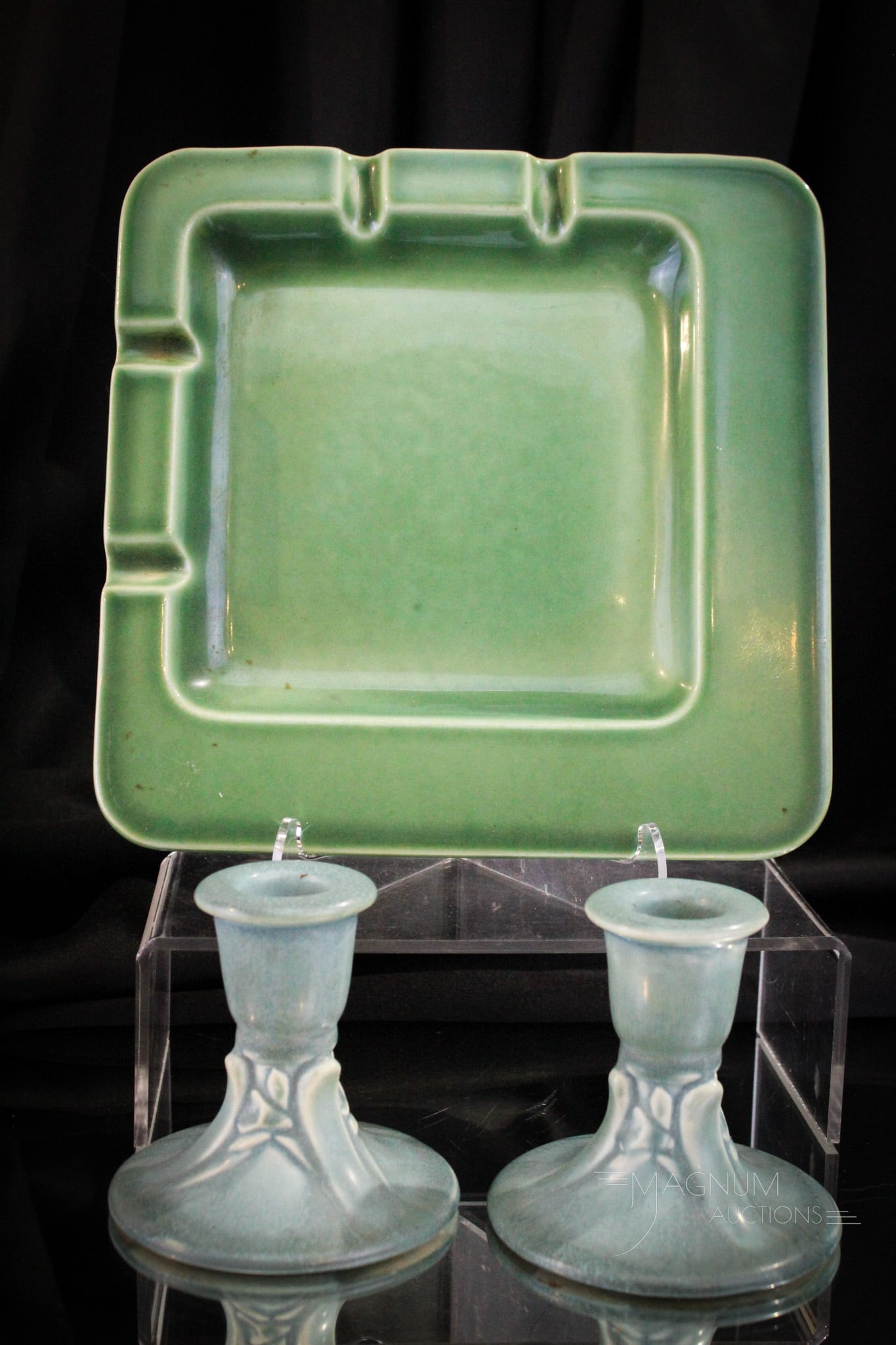 3 pc Lot Rookwwod Pottery: Three fine examples of Rookwood pottery. Example 1. glossy green ashtray "LV", "7III". Exdample 2. A pair of matte blue candlesticks, "XLVI", "6532".