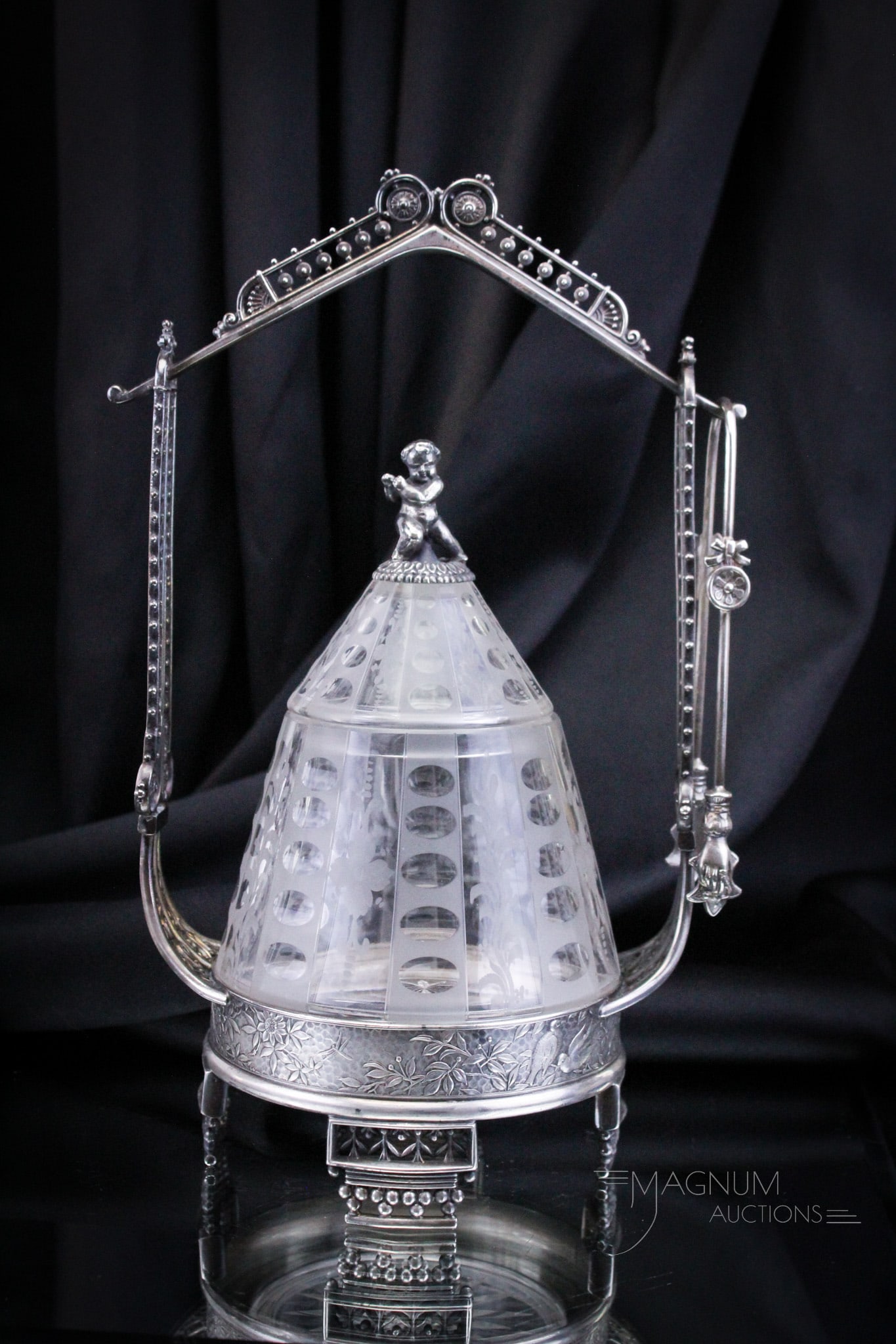 Outstanding Victorian Meriden Silverplate Pickle Castor with Cherub: A super find folks! This fine signed Meriden Victorian silverplate pickle castor complete with etched conical form insert and original lid with cherub seated at the top. Castor measures 12" tall.