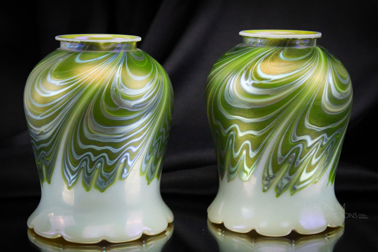 Tiffany Attributed Pair of Art Glass Pulled Feather Shades: Striking pair of attributed to Tiffany art glass pulled feather shades. Each finely made shade features green pulled feather design with gold irridescent interior. Each shade measures 5 1/4" tall, wit