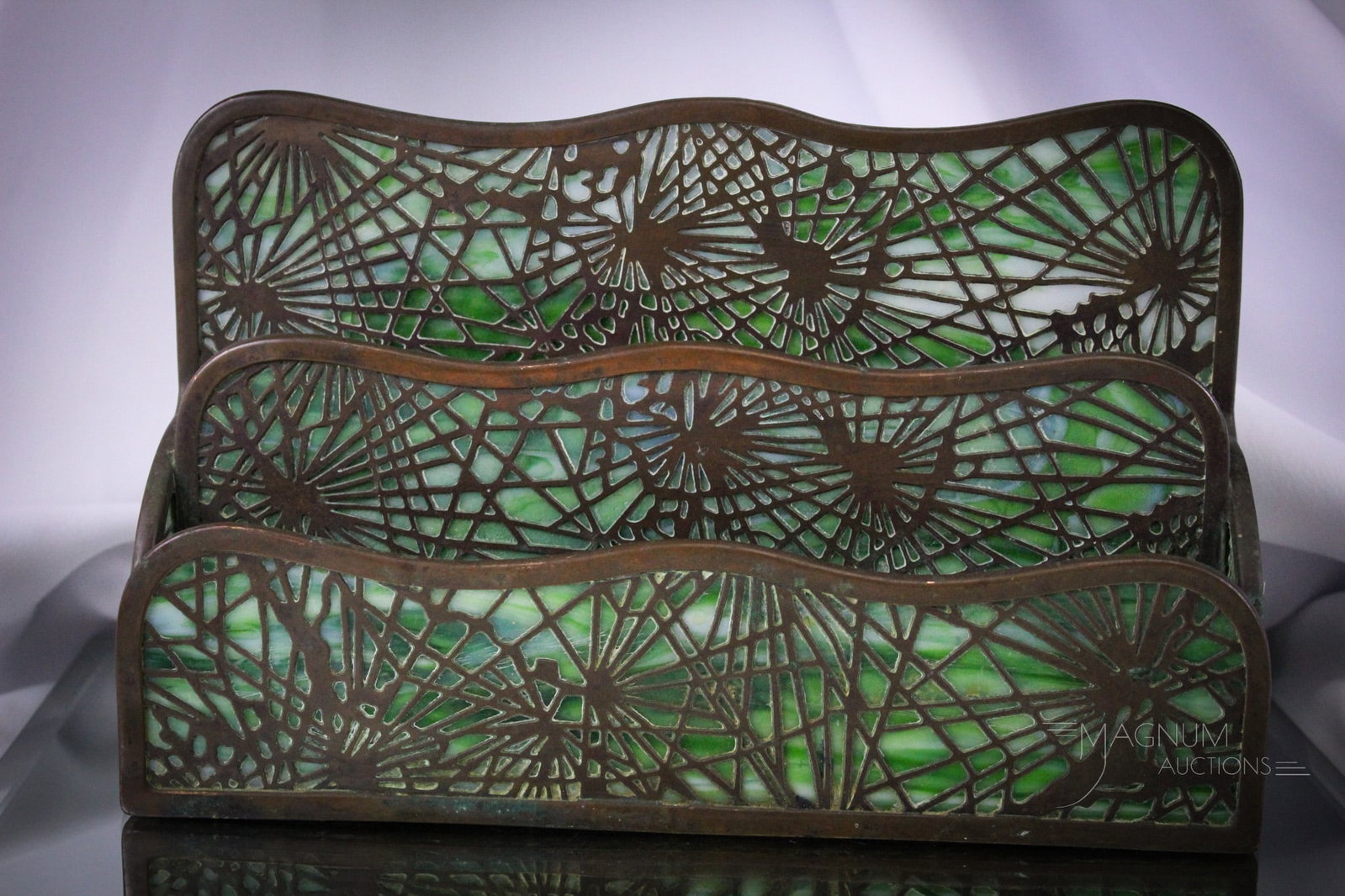 Signed Tiffany Studios New York Pine Needles Letter Holder: Fine offering of a signed, "Tiffany Studios New York" overlay letter holder in the Pine Needles pattern. This example measures 6" tall, 10" long. Glass with damage as shown on back panel.