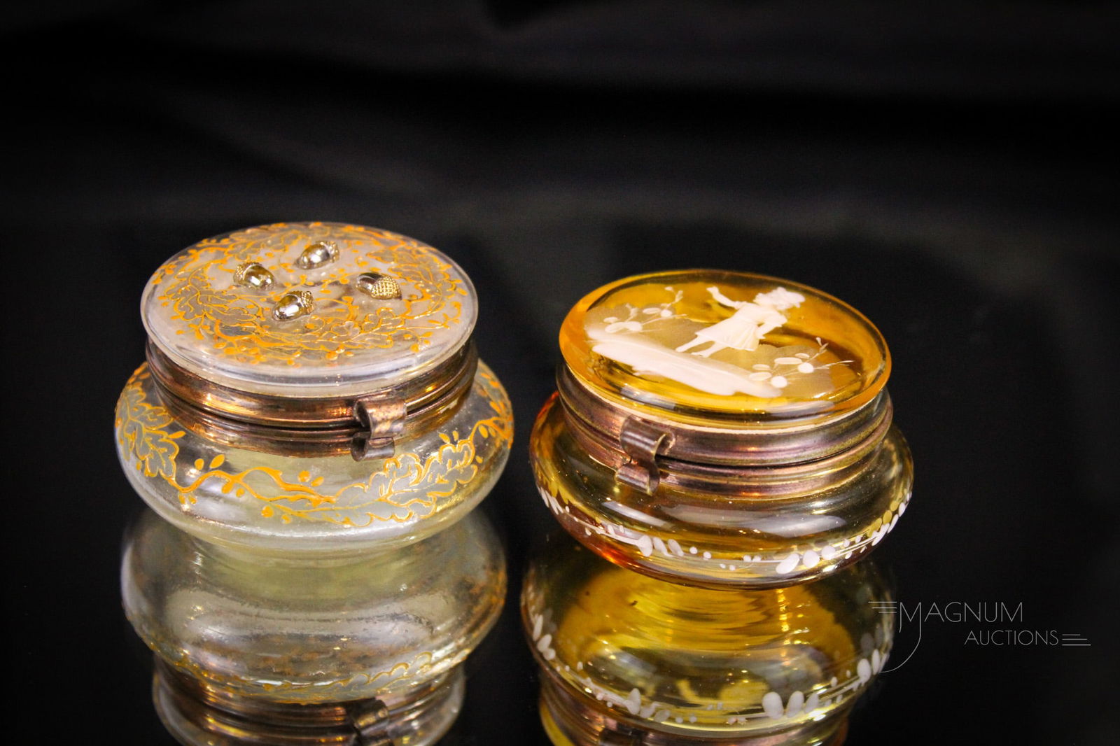 2 pc Lot Pill Patch Boxes Moser & Mary Gregory Enameled Victorian Glass: Select offering of two fine pill or patch boxes. One finely enameled Moser example with applied acorns. The other is an amber with Mary Gregory decoration. Largest measures 1 1/4" tall.