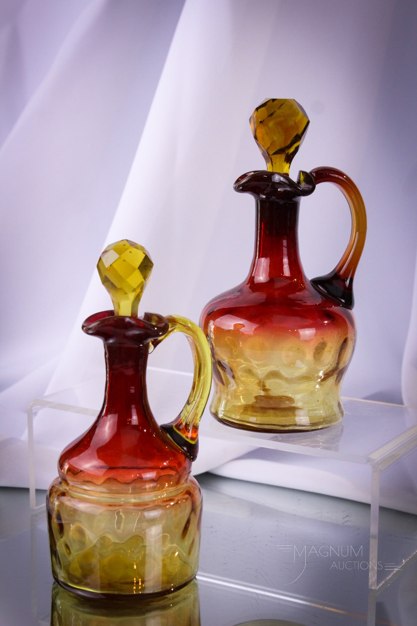 2 pc Lot Mt. Washington Victorian Amberina Cruets Winchester & More: Two beautiful Victorian Mt. Washington amberina cruets. One example is in the Winchester pattern. Both retain original stoppers. Tallest measures 6 1/2". Provenance: This item is from the private coll