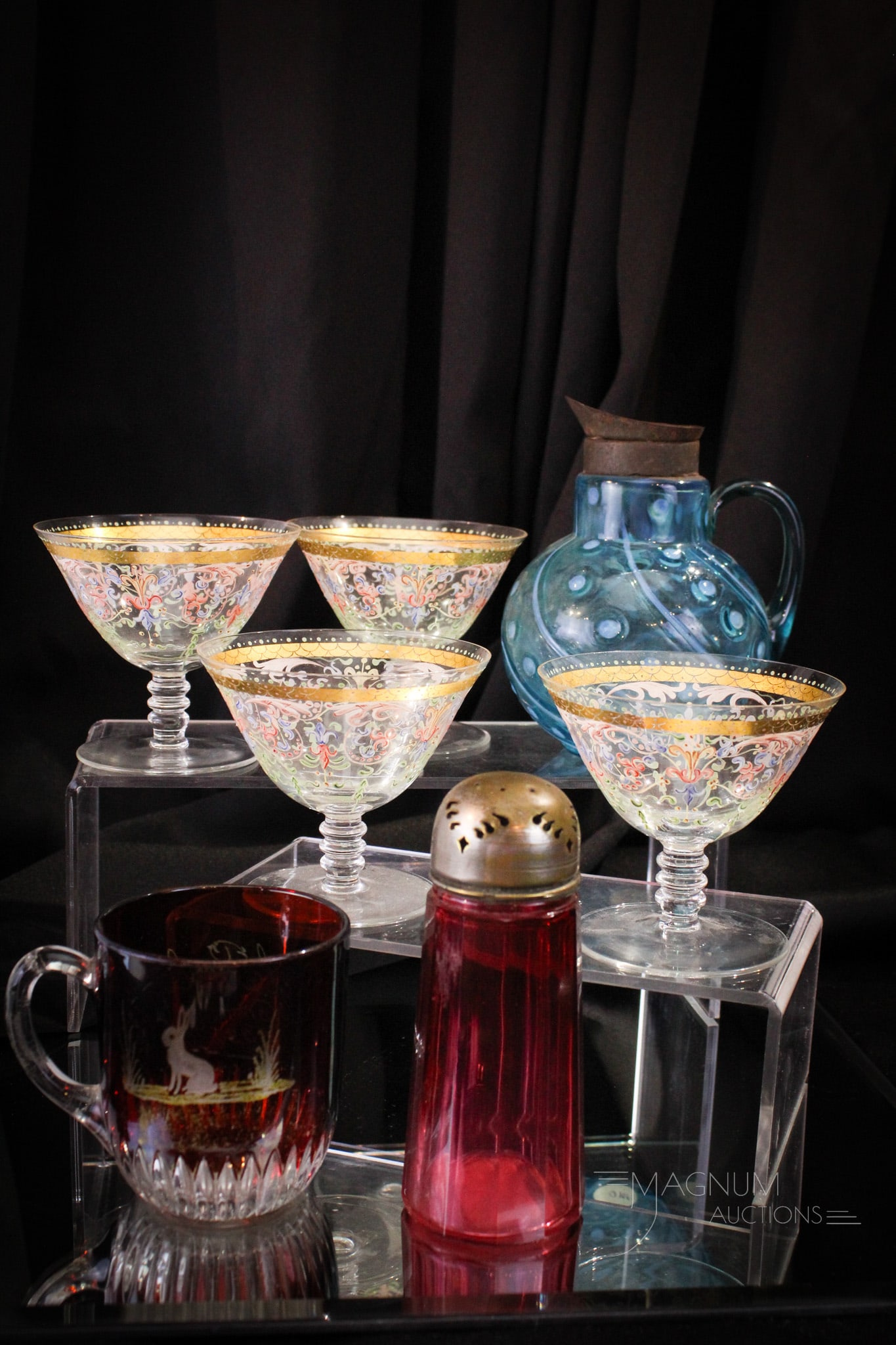 7 pc Lot Victorian Glass & More: Great offering in this seven piece lot of glass. Lot is comprised of a Victorian glass syrup and sugar shaker. A red flashed mug. All of this completed by a set of four enameled sherbert cups. Tallest
