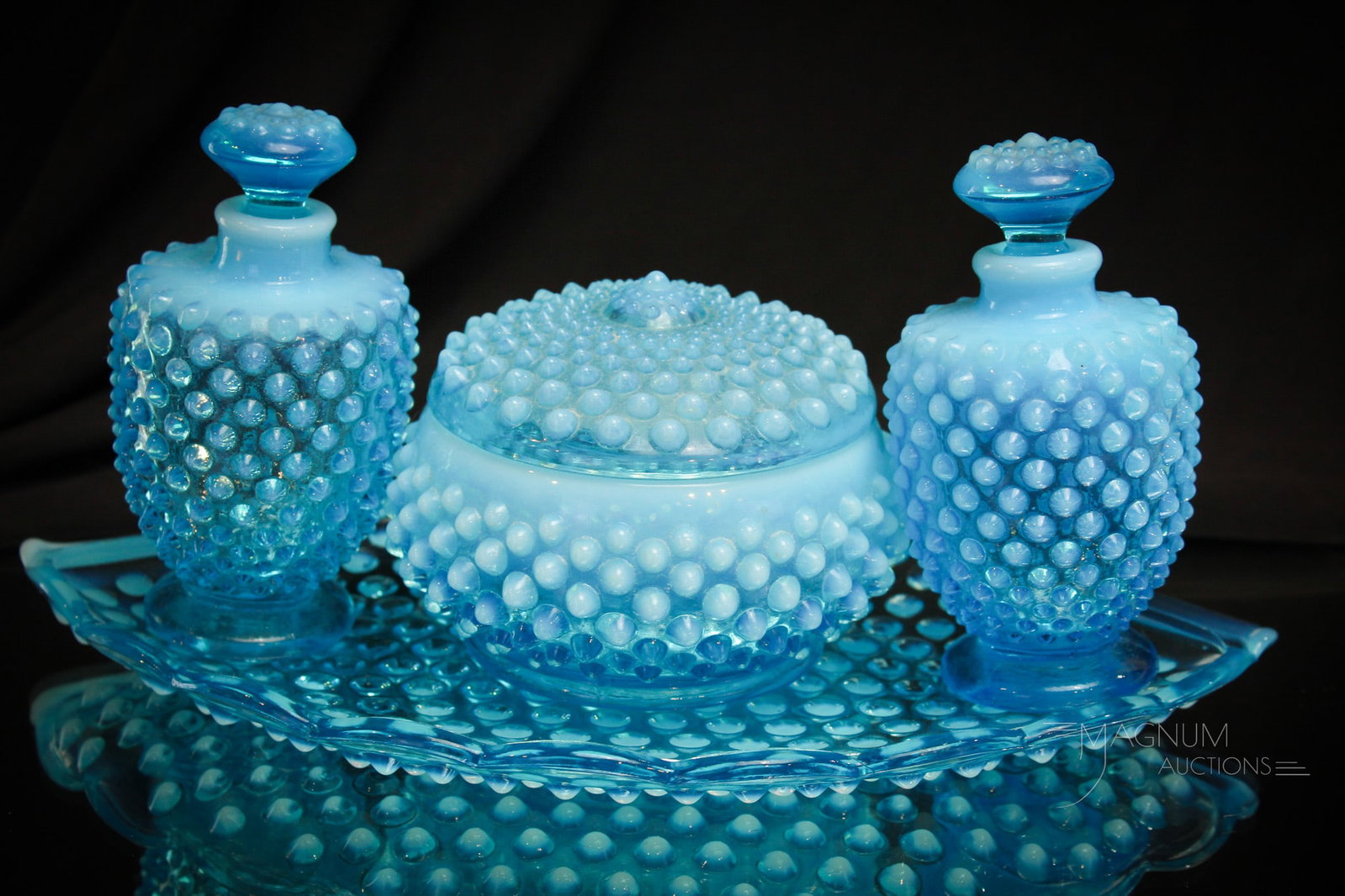 Fenton Blue Opalescent Hobnail Perfume Vanity Bottle Set: Striking blue opalescent Fenton glass hobnail vanity perfume bottle set complete with tray. Fine example with super coloring! Set measures 5" tall, 10 1/2" long.