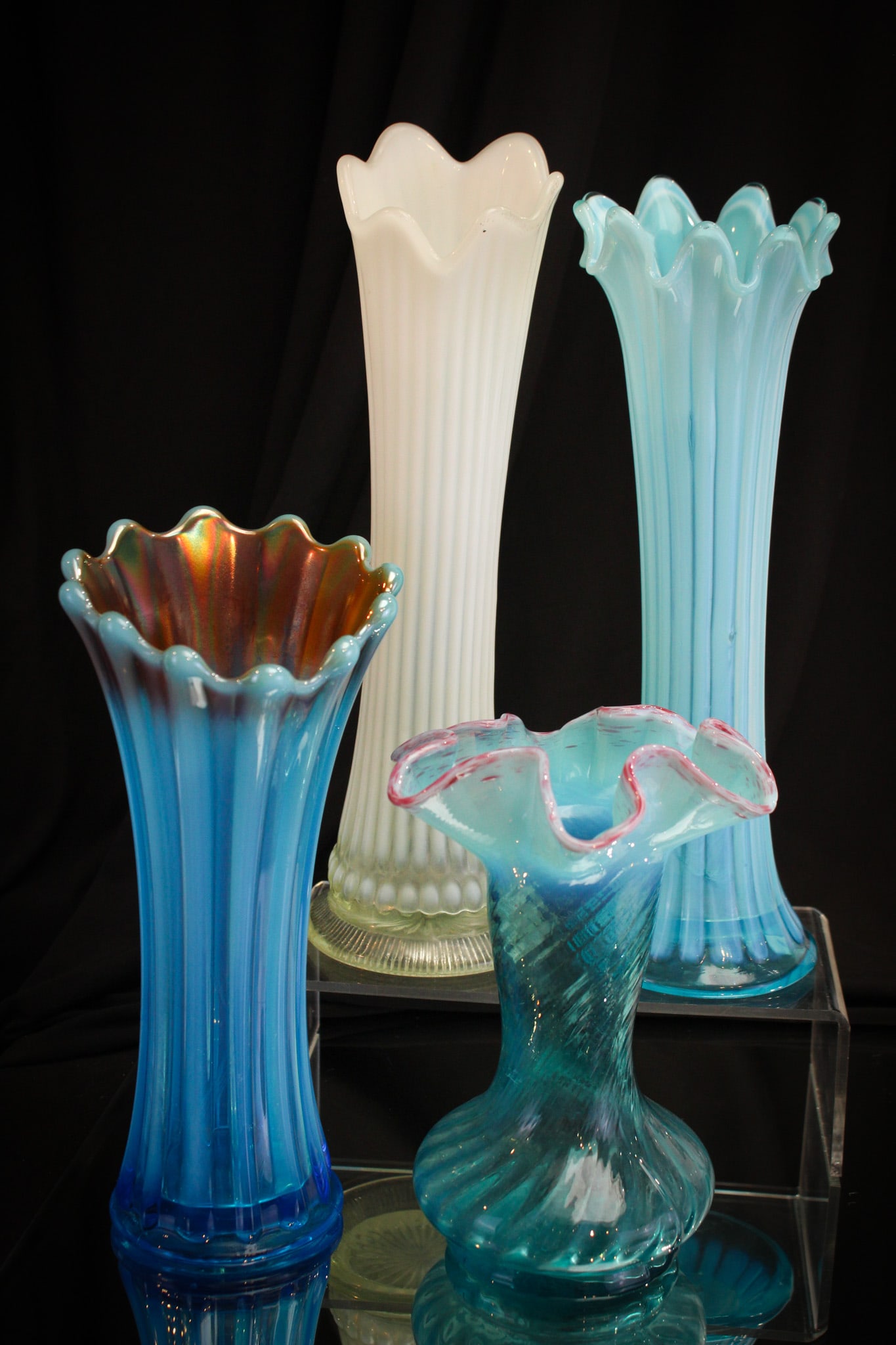 4 pc Lot Opalescent Victorian Glass Swung Vases: Four fine examples of Victorian opalescent swung vases. Included in the offering is a Thin & Wide Stripe, a Convex Rib, a Corinth with marigold carnival coloring, and completed by a Tiny Tears pattern