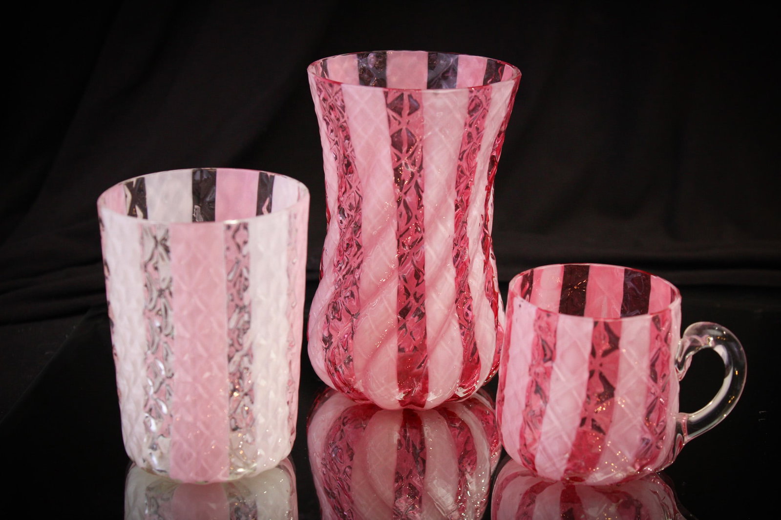 3 pc Lot Victorian Phoenix Diamond Quilt Wide Stripe Glass: Select offerings in this lot of attributed to Phoenix glass diamond quilt wide stripe pattern. Included in the lot is a pink and white tumbler, a cranberry with white stripe punch cup, and completed b