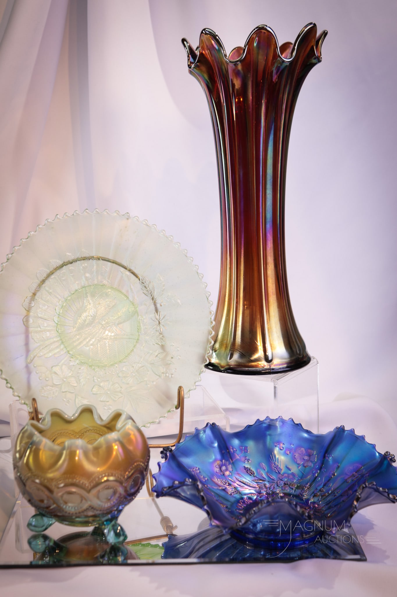 4 pc Lot Northwood Carnival Glass: Four fine examples of Northwood carnival glass. This lot includes a Thin Rib vase in amythest, an aqua opal Beaded Cable rose bowl, an electric blue Good Luck Bowl, and finally an ice green Peacock on
