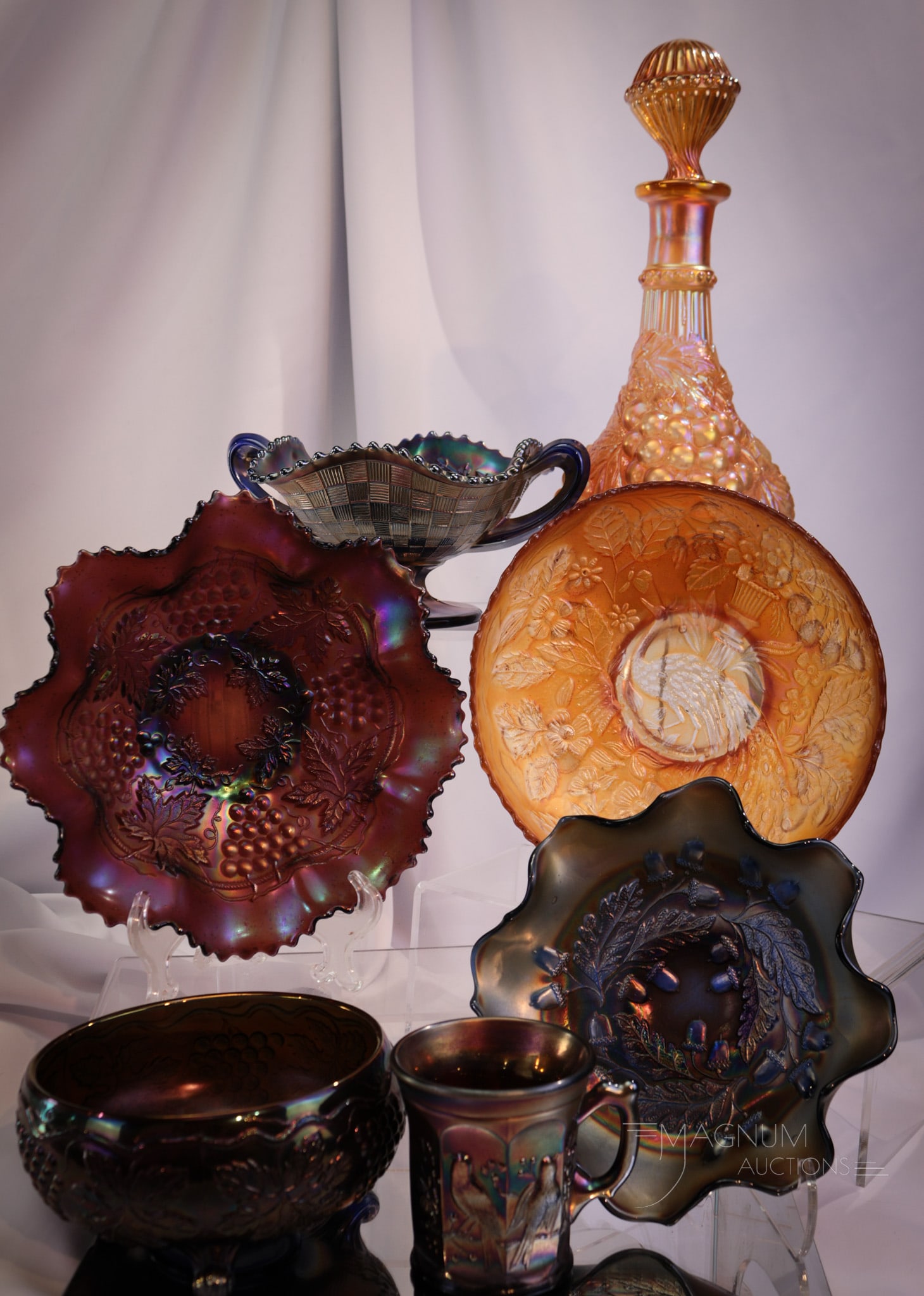 7 pc Lot Northwood & Fenton Carnival Glass: A fine assortment of Northwood and Fenton carnival glass in various colors and patterns. This lot includes a purple Singing Birds mug, a blue Three Fruits bon-bon, a blue Vintage ferner, an amythest G