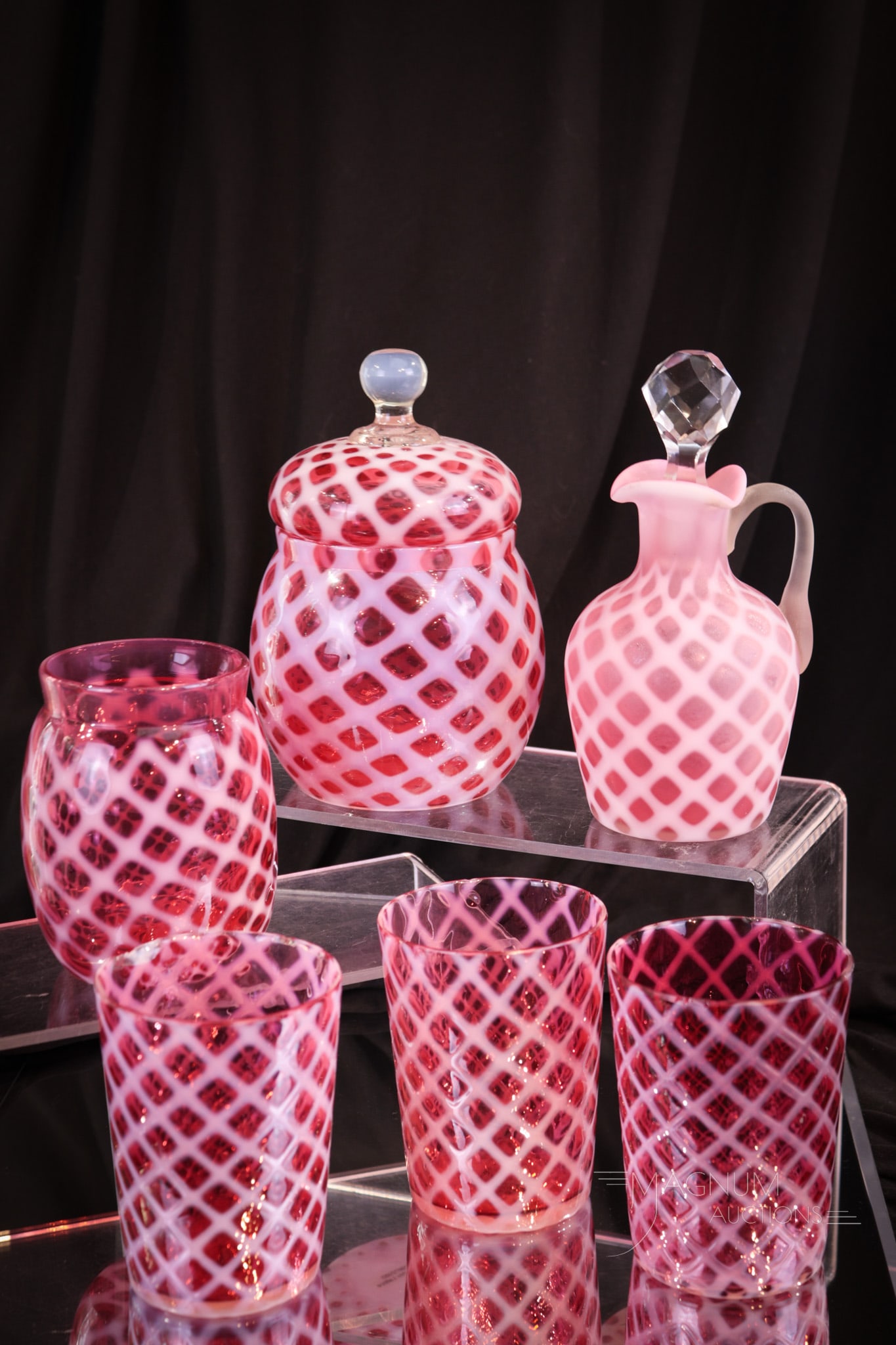 6 pc Lot Cranberry Opalescent Bubble Lattice Victorain Glass: Six select examples of cranberry opalescent Victorian glass in the Bubble Lattice pattern. This lot includes a cruet in satin finish, a covered sugar bowl, a spooner, and three tumblers. Tallest measu