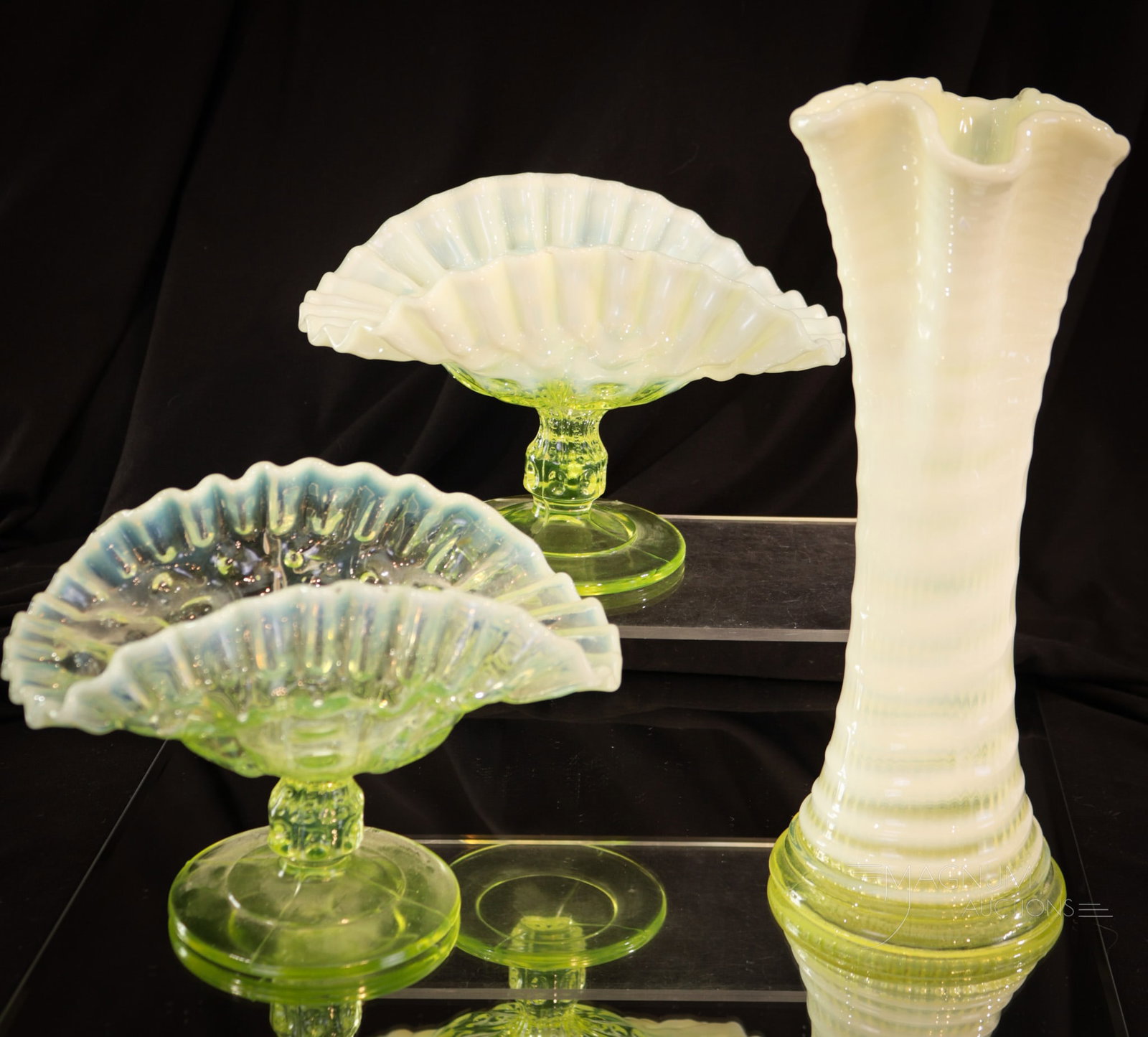 3 pc Lot Vaseline Opalescent Glass: Three delights sure to please the Vasie-lover in your life. This lot is comprisede by a Ribbed Spiral vase and two thumbprint compotes with pedestal bases. Tallest measures 9 1/2" tall.
