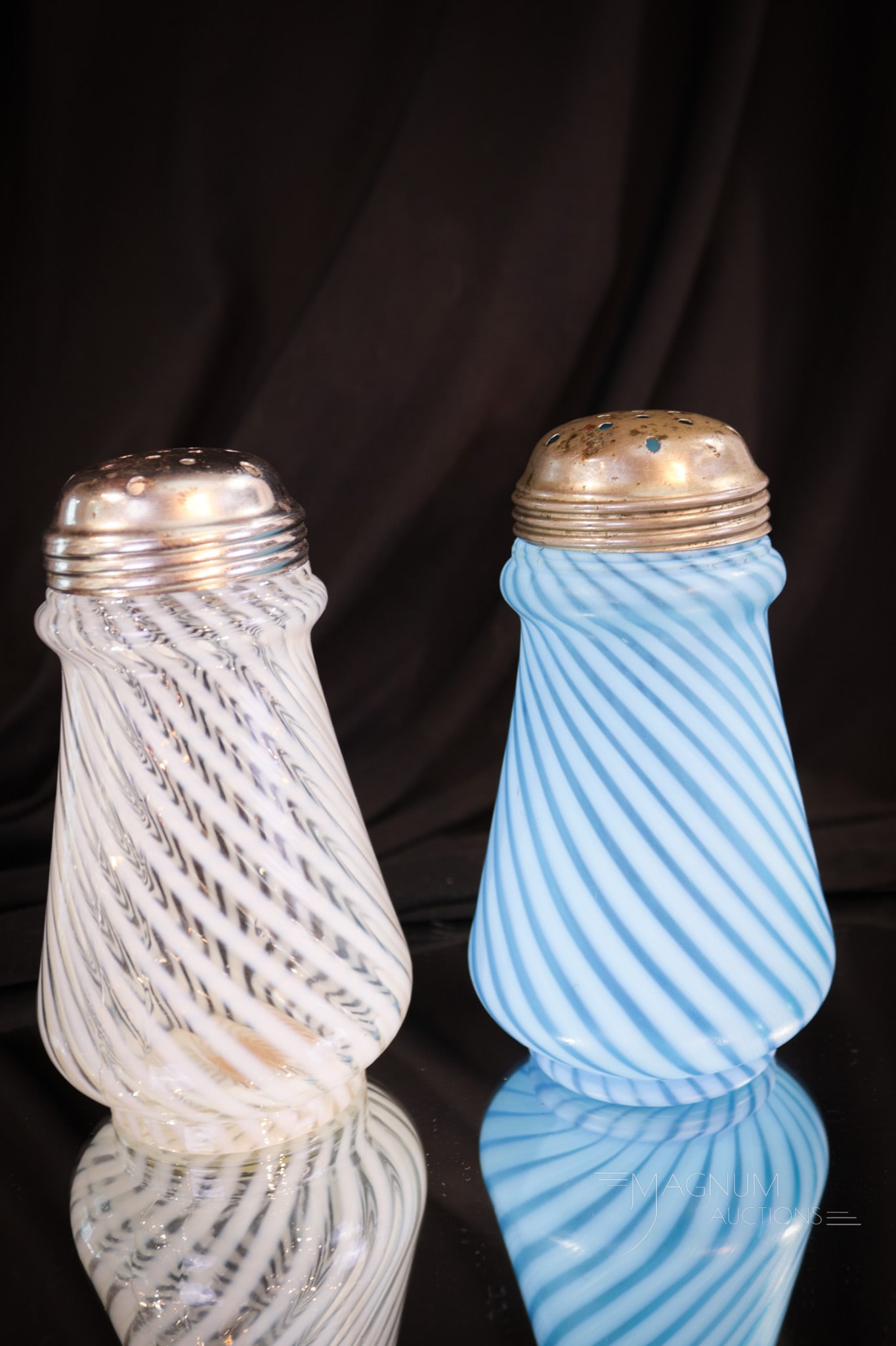 2 pc Lot Hobb's Victorian Glass Opalescent Sugar Shakers: Two fine example of sugar shaker of the Victorian age made by Hobb's. One in crystal opal. One in blue opal. Both in the swirl pattern. Each lovely. Each measures 5 1/2" tall.