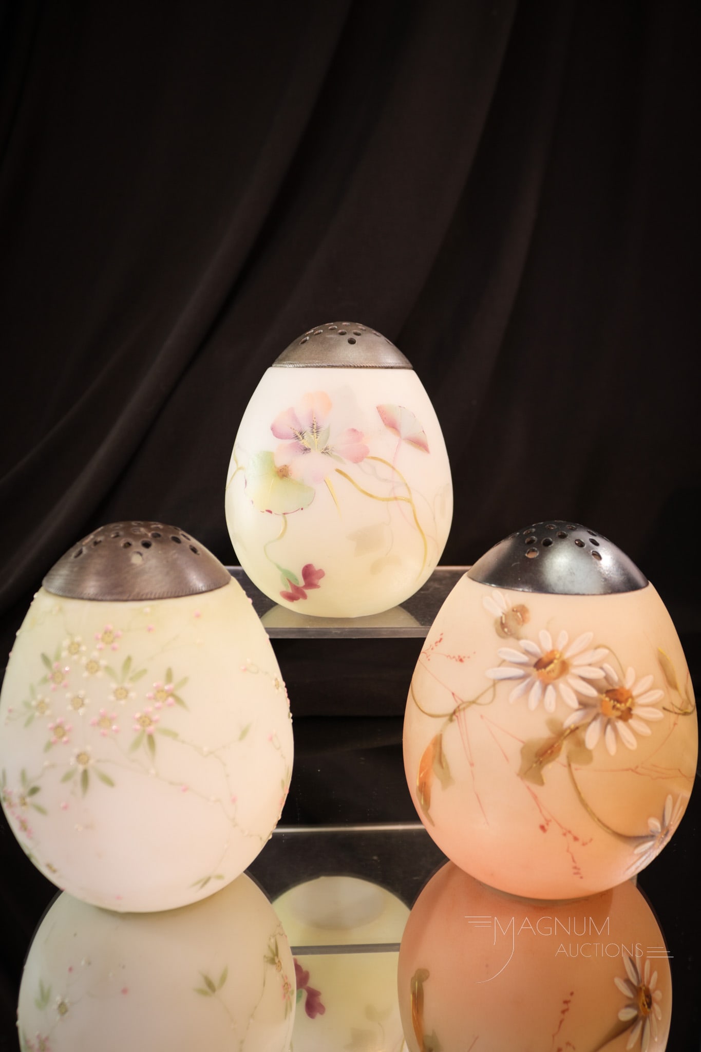 3 pc Lot Mt. Washington Enameled Glass Egg Sugar Shakers: Three fine examples of Mt. Washington Victorian egg sugar shakers. Each measures 4" tall. Each with a little different floral motif. Each is collection enhancing.