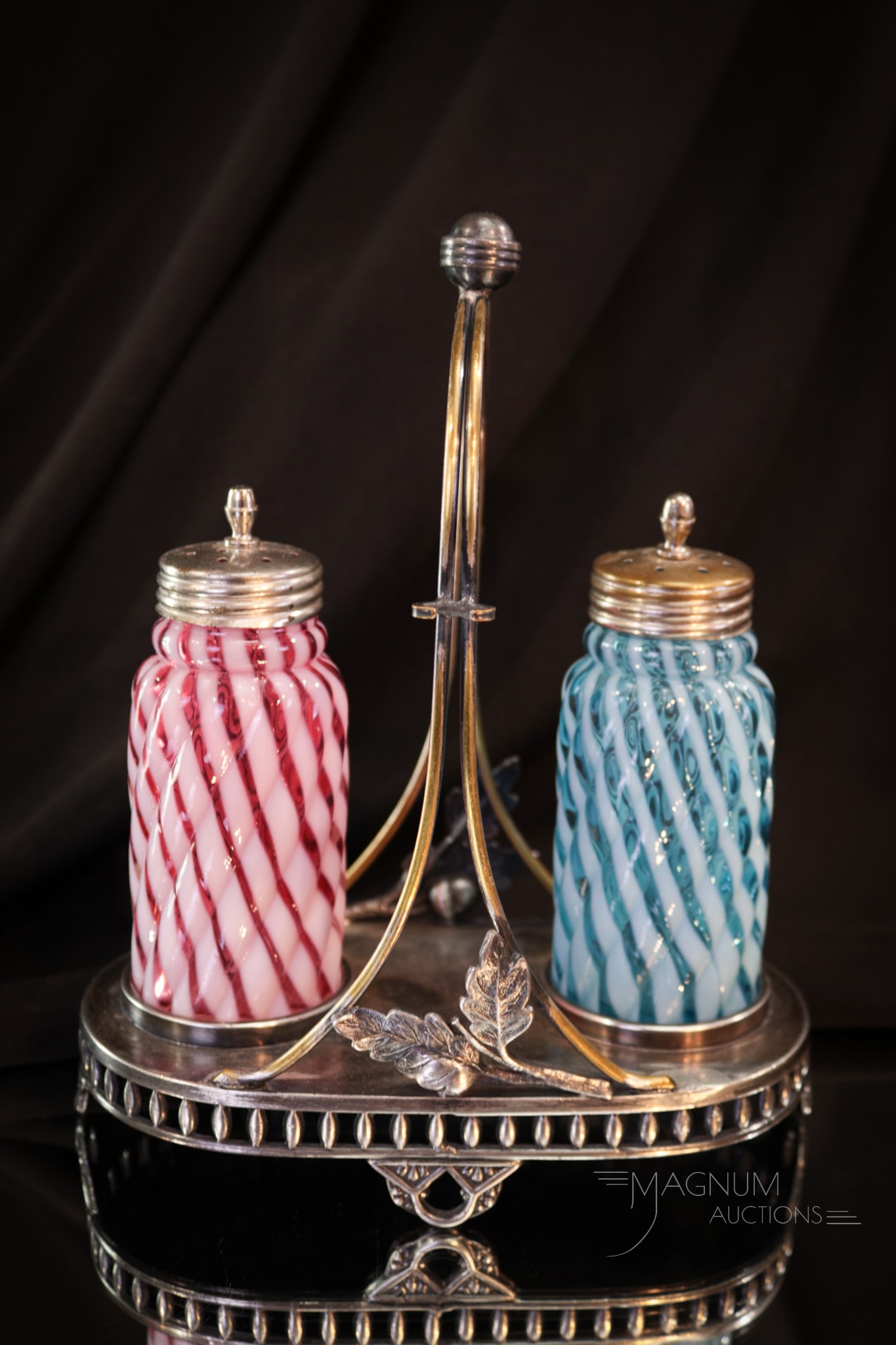 Pairpoint Victorian Silver Plate Opalescent Shaker Set: This pair of cranberry and blue opalescent reverse swirl salt shakers in a signed Pairpoint silver plate holder is super. Make sure to add this to your bid list today! Measures 7 1/4" tall.
