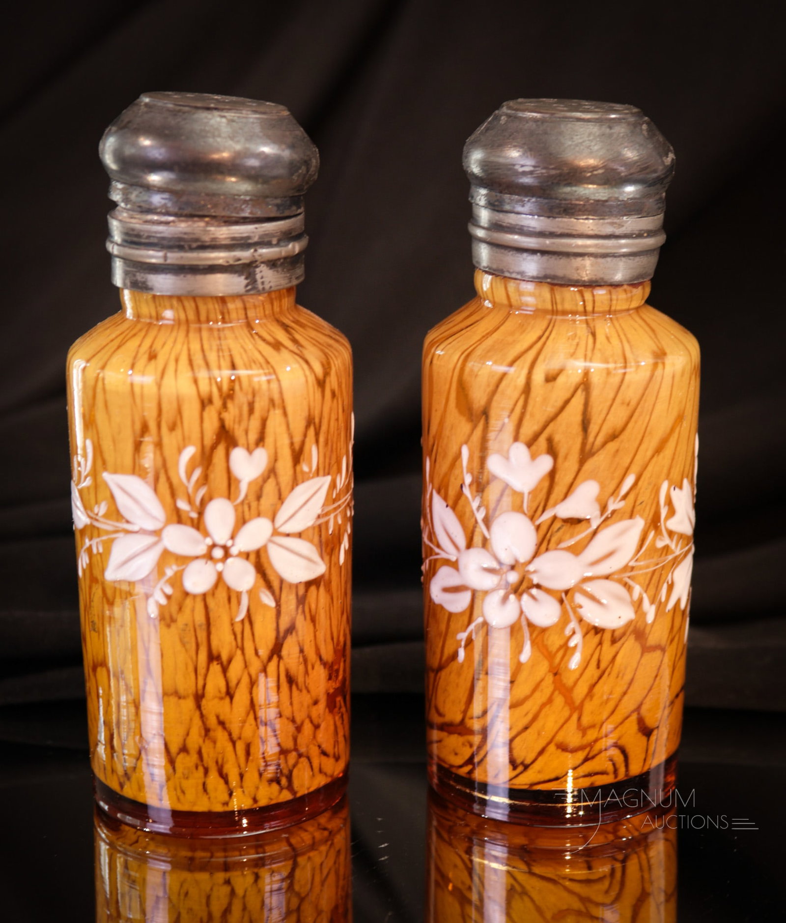 Pair Amber Rain Victorian Enameled Glass Salt Shakers: Fine pair of amber spattern Rain pattern shakers with enameled floral decorations. Each shaker complete with two-piece metal top. Each measures 4" tall.