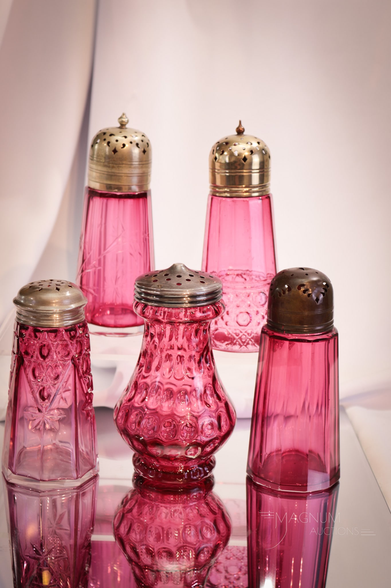 5 pc Lot Victorian Cranberry Glass English Sugar Shakers Muffineers: Selections abound in this offering of five unique Victorian cranberry English sugar shakers or Muffineers. Each is complete with a two-piece metal top. Tallest measures 5 3/4"