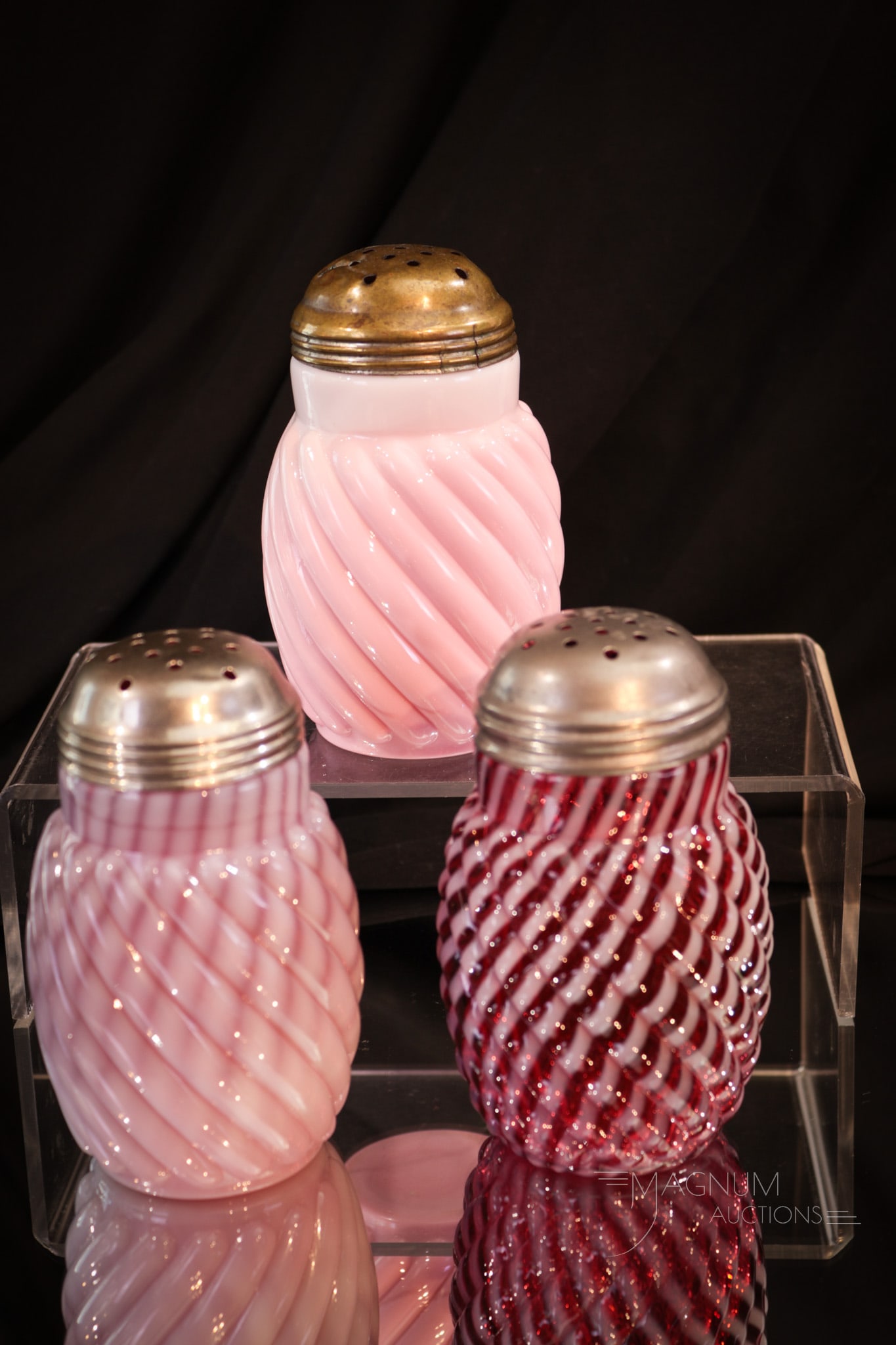 3 pc Lot Reverse Swirl Victorian Opalescent & More Sugar Shakers: Three fine selections in Victorian glass sugar shakers in the Reverse Swirl pattern. Two unique cranberry opalescent examples along with a peachbloom. Each measures 4 1/2" tall.