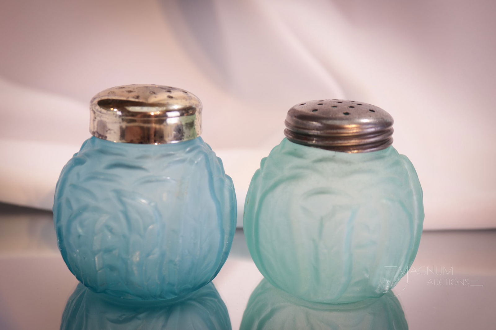 Pair Blue Satin Northwood Leaf Mold Victorian Glass Shakers: Two great examples of the Northwood Leaf Mold pattern. Each in a unique shade of blue. Each shaker measures 2 1/2" tall.
