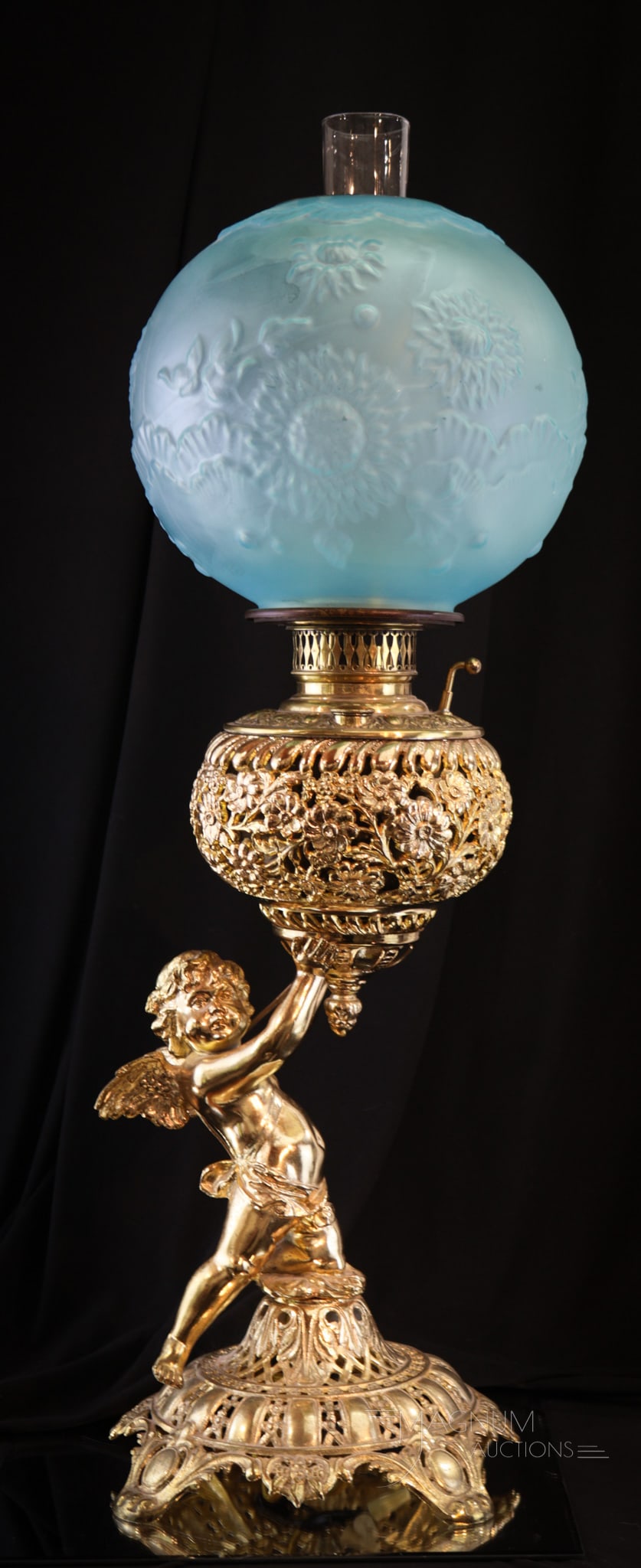 Victorian Cherub Banquet Oil Lamp: Superb figural banquet lamp with winged cherub at the base holding the font. Lamp is completed by a frosted Victorian ball shade in Chrysanthemum pattern. Lamp measures 26" tall. Lamp has been electri