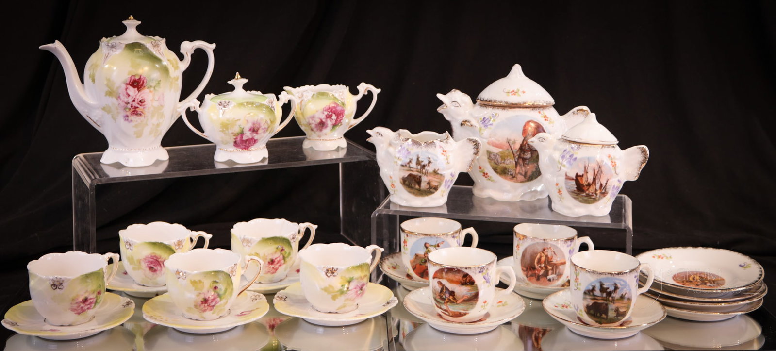 Unmarked R.S. Prussia & R. S. Germany 13 pc Lot Child's Tea Sets: Thirteen pieces of unmarked R.S. Prussia and Germany child's tea sets in the Robinson Caruso decoration. Unmarked R.S. Prussia teapot lid finial displays three of the five petals chipped and a chip to