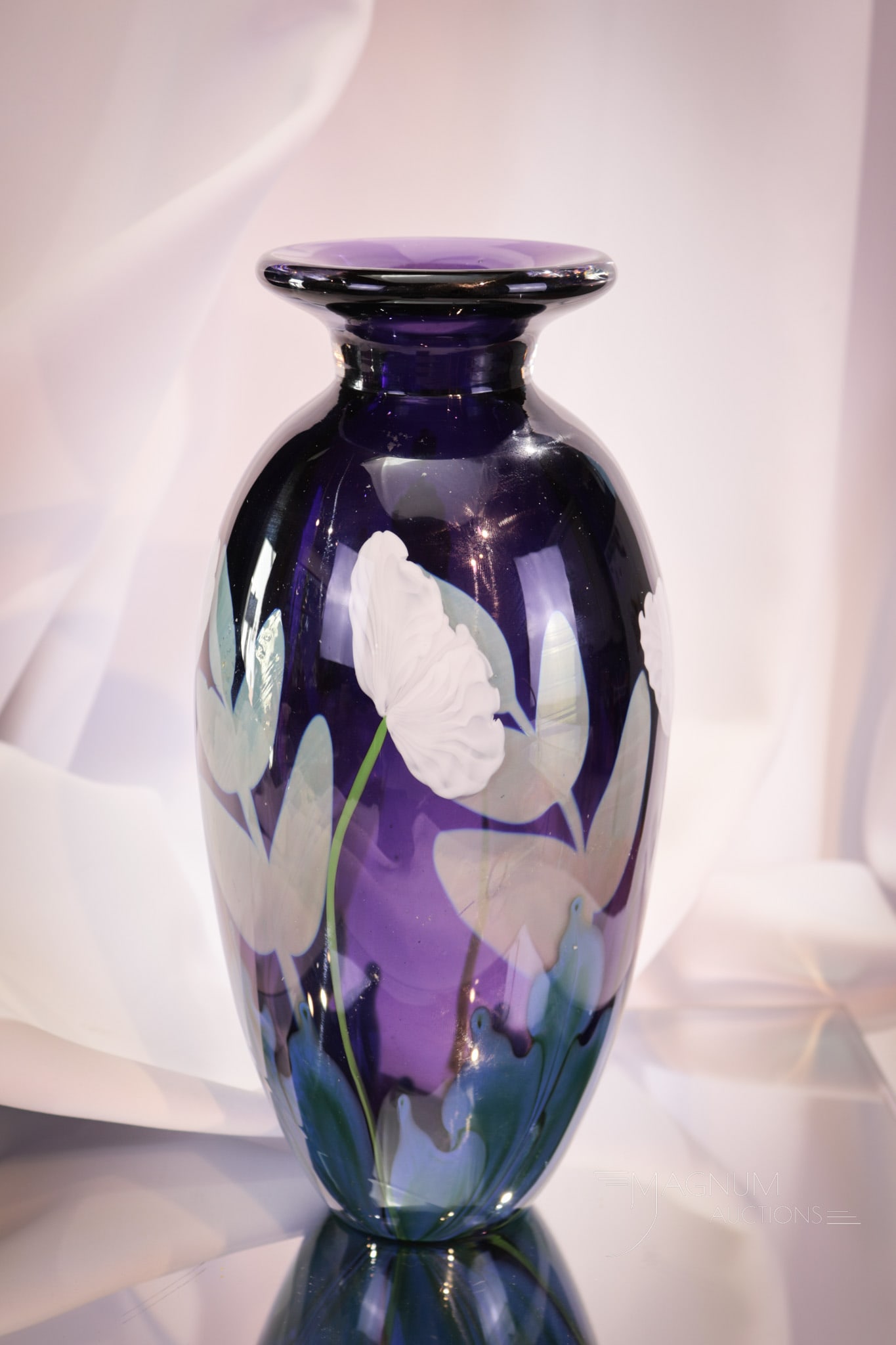 Lundberg Studios Pasperweight Glass Vase: A find in Lundberg studios glass. This paperweight vase with purple and white flowers is marked, "7,02 and 1/1 Sketch." Vase measures 10 1/4" tall.