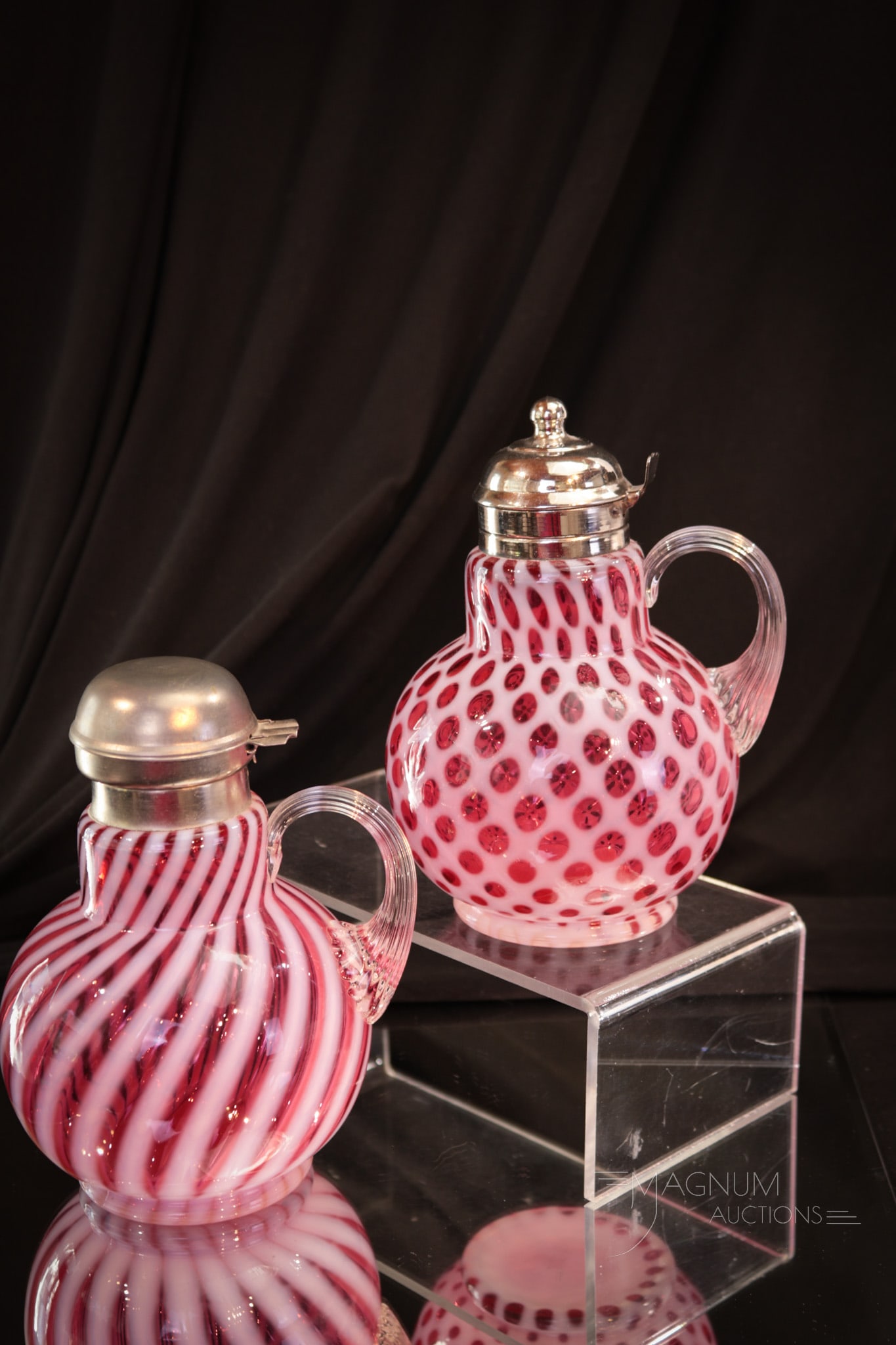 2 pc Lot Fenton Wright Cranberry Opalescent Syrup Pitchers: Two delights in Fenton art glass for L.G. Wright in cranberry opalescent. One in the Honeycomb pattern. The other in the Swirl pattern. Tallest measures 6 1/2".