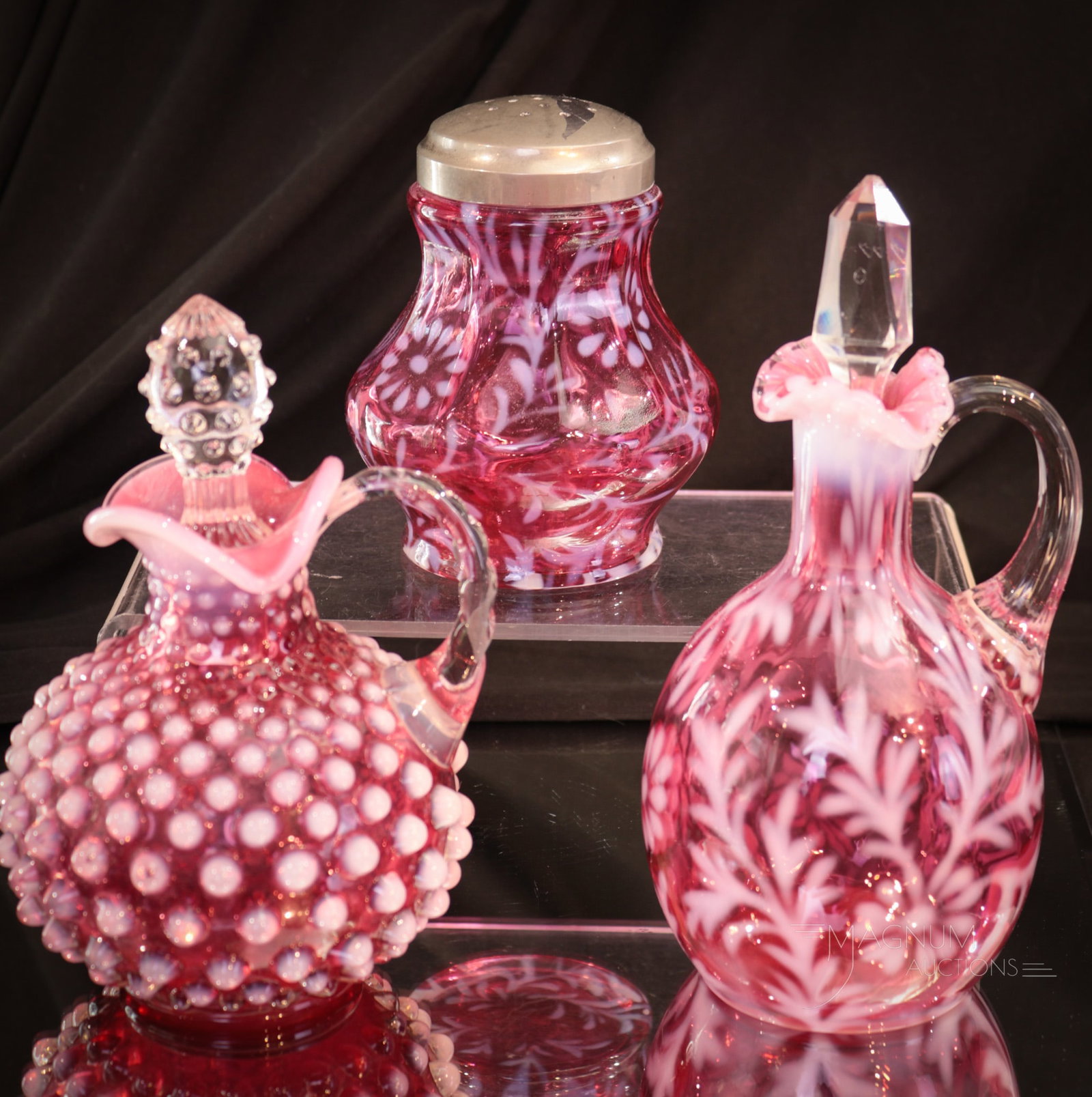 3 pc Lot Fenton Wright Cranberry Opalescent Glass Cruets & Sugar Shaker: Select offering of three pieces of Fenton L.G. Wright cranberry opalescent glass. Included in this generous offering is a Hobnail cruet along with a Daisy & fern pattern cruet and sugar shaker. Talles