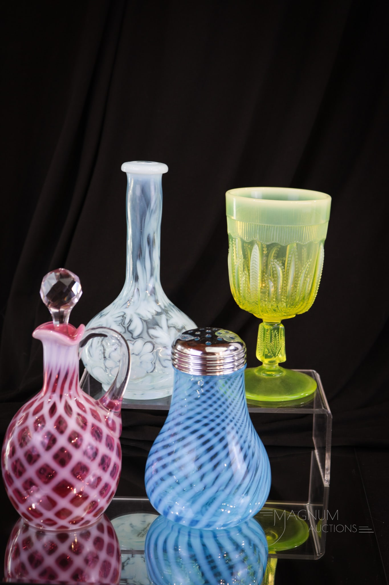 4 pc Lot Fenton Wright Opalescent Glass: Four select examples of Fenton and L.G. Wright art glass. Comprising the lot is a cranberry lattice cruet, a blue opalescent barber bottle, a blue opalescent sugar shaker, and finally a vaseline cactu