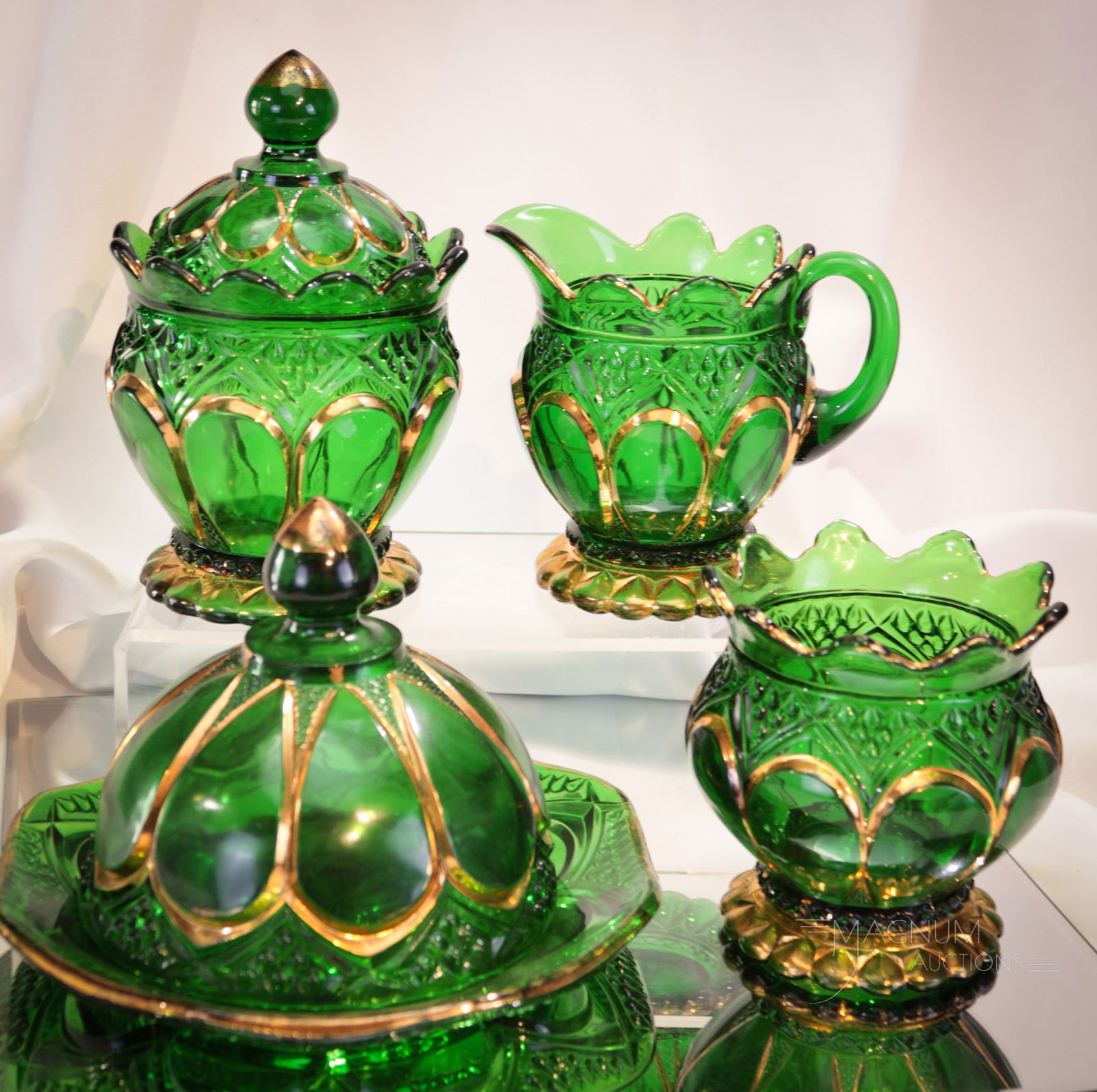 4 pc Lot Riverside Duchess Glass Table Set: Four finds in Riverside glass Duchess pattern table set items in green with gold decoration. Included in this lot is a butter, sugar, creamer, and spooner. Tallest measures 6 1/2". Butter base flange