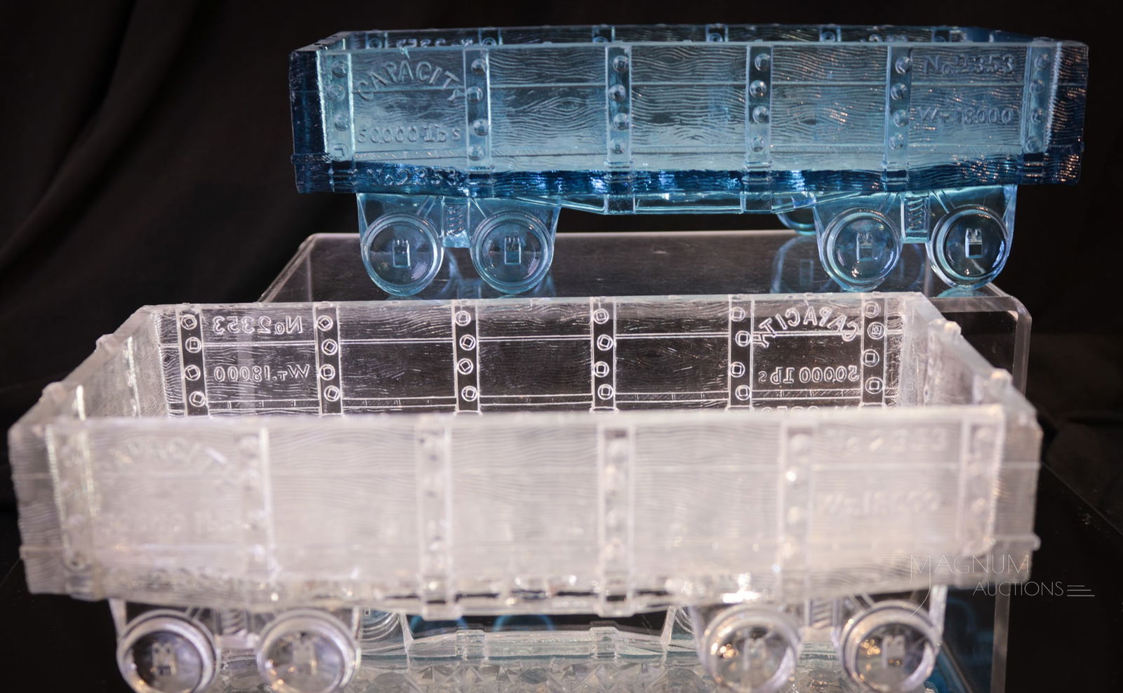 2 pc Lot Victorian Novelty Glass Train Cars: Two highly collectible Victorian Novelty glass train cars. One in clear, one in blue. Each measures 2 1/4" tall, 8 1/4" long. Provenance: This item is from the private collection of Bill & Betty Stro