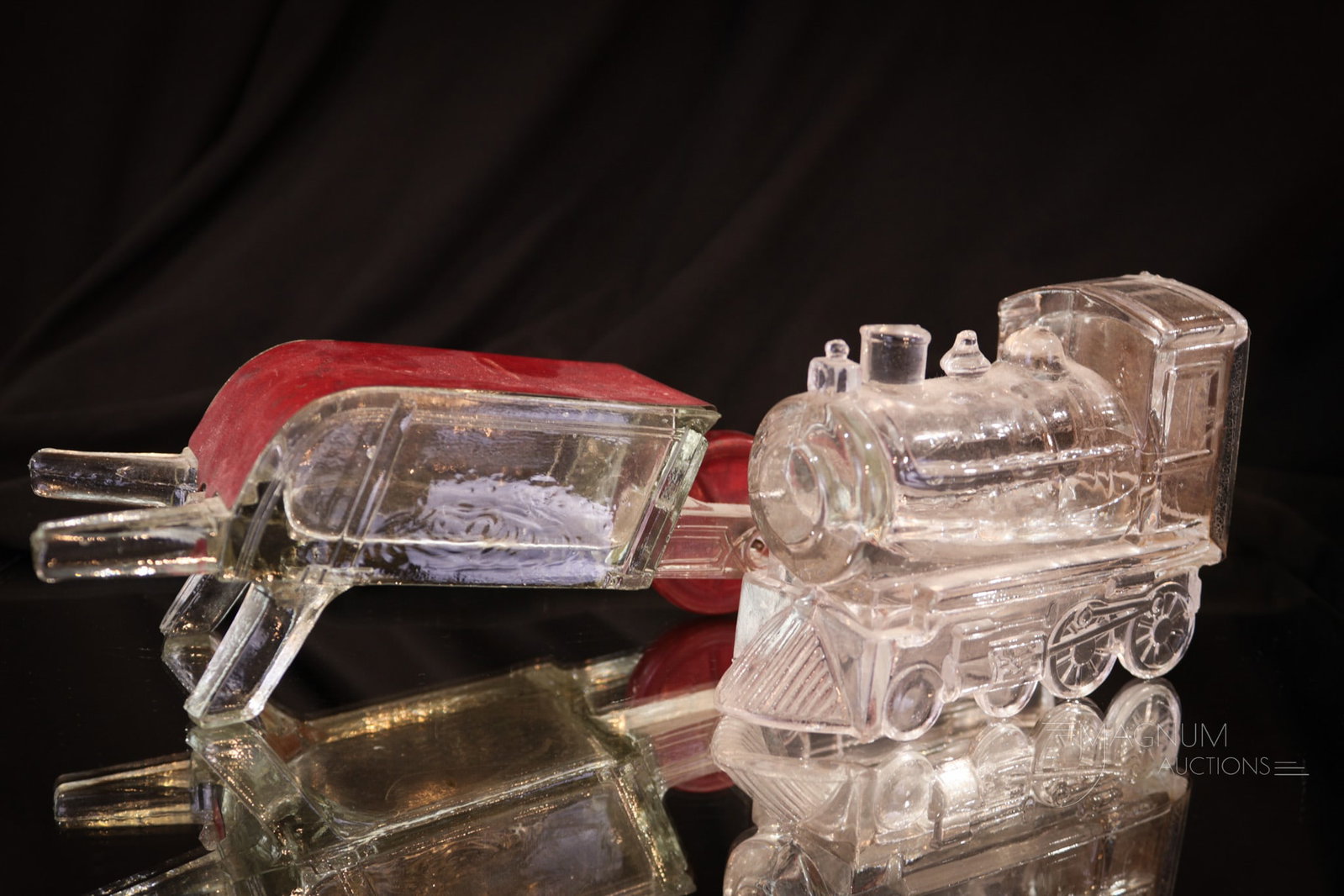 2 pc Lot Victorian Figural Novelty Locomotive and Wagon Candy Containers: Two charming Victorian glass novelty candy containers in this offering. A figural locomotive along with a wagon. Tallest measures 3". Provenance: This item is from the private collection of Bill & Bet