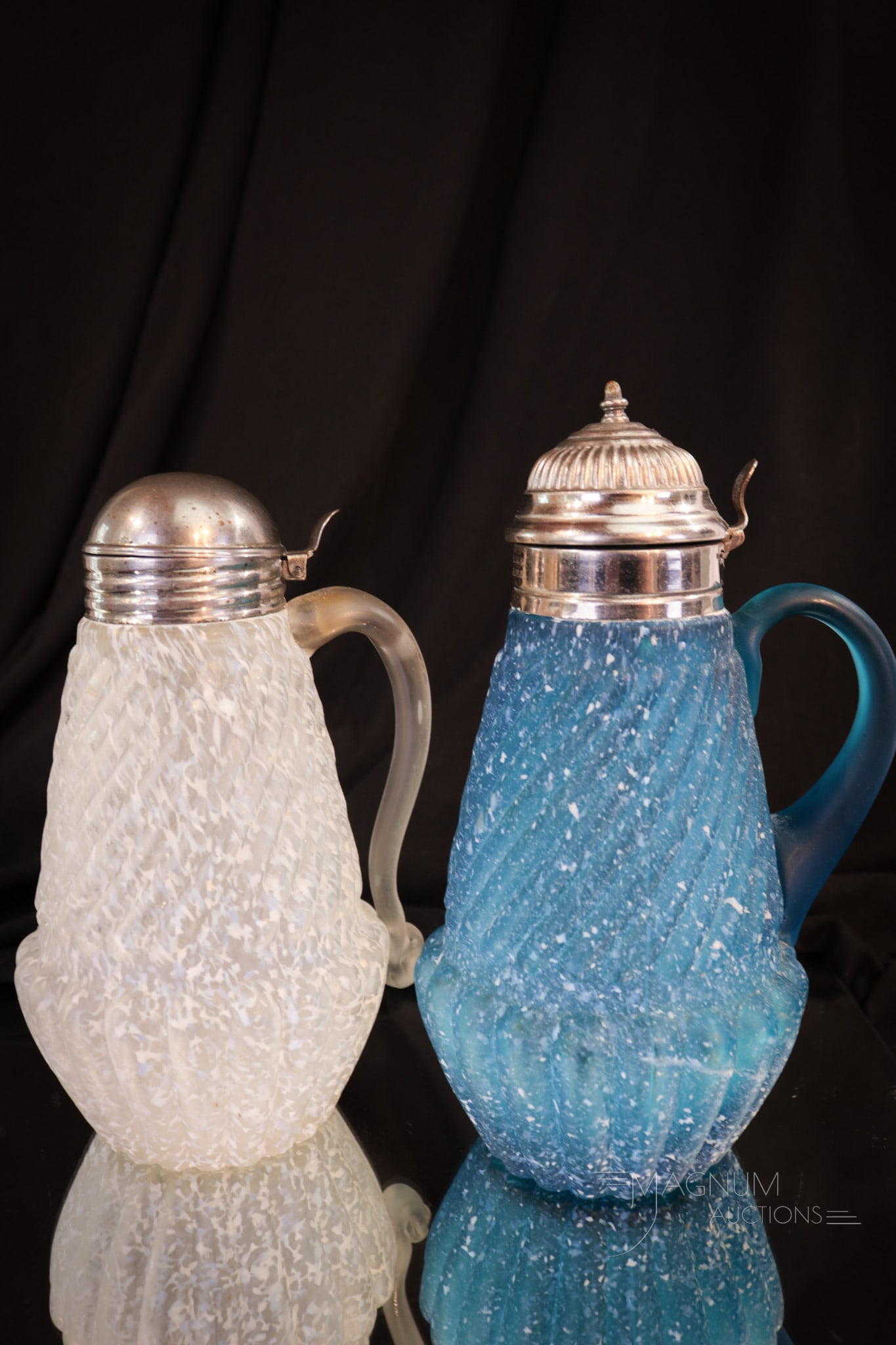 2 pc Lot Northwood Chrysanthemum Base Victorian Syrup Pitchers: Two finds in Victorian frit finsihed syrup pitchers. One in blue and one in crystal. Both in the Chrysanthemum Base pattern by Northwood. Each of these complete with applied handle in unique designs. 