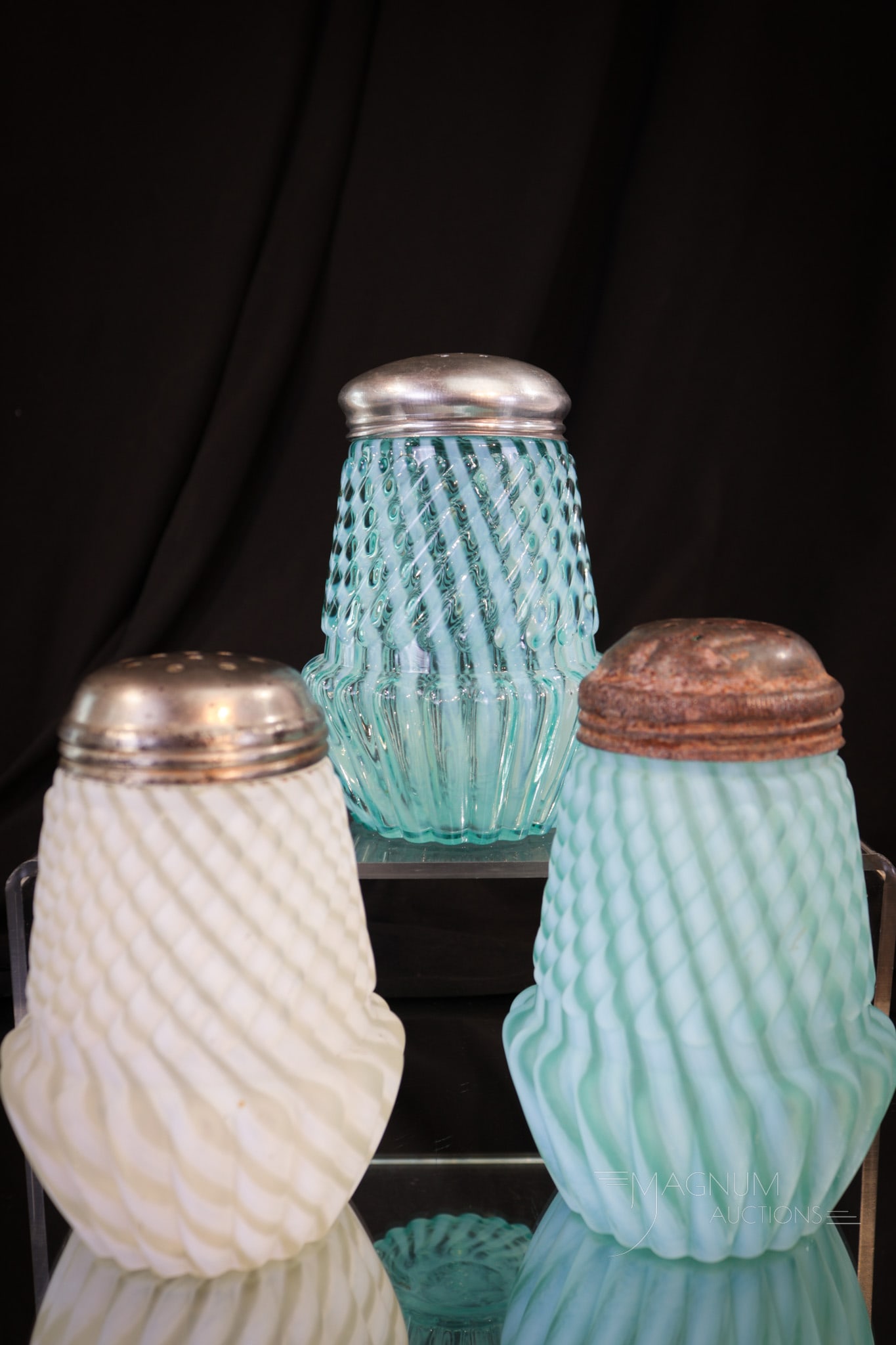 3 pc Lot Northwood Chrysanthemum Base Swirl Victorian Sugar Shakers: Three unique examples of the popular Northwood pattern Chrysanthemum Base swirl. We have a blue opal, a blue opal satin finish, and a crystal opal in satin finish. Each measures 4 1/2" tall.