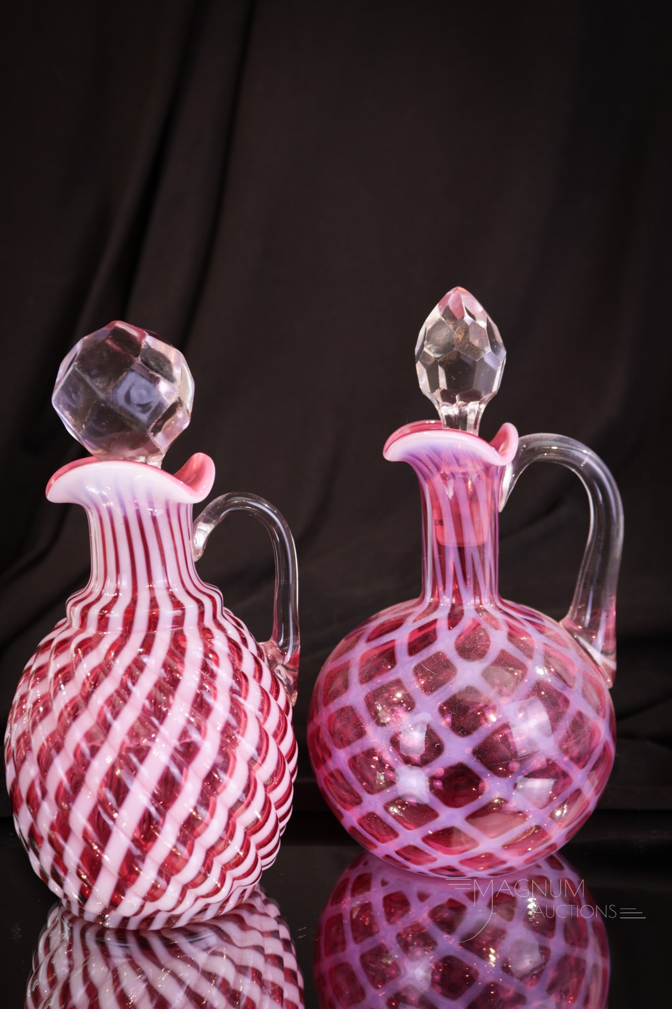 2 pc Lot Victorian Cranberry Opalescent Glass Cruets: Two fine examples of cranberry opalescent Victorian glass cruets. One in the Reverse Swirl pattern. One in the Bubble Lattice pattern. Each with great color. Tallest measures 6 1/2" tall.