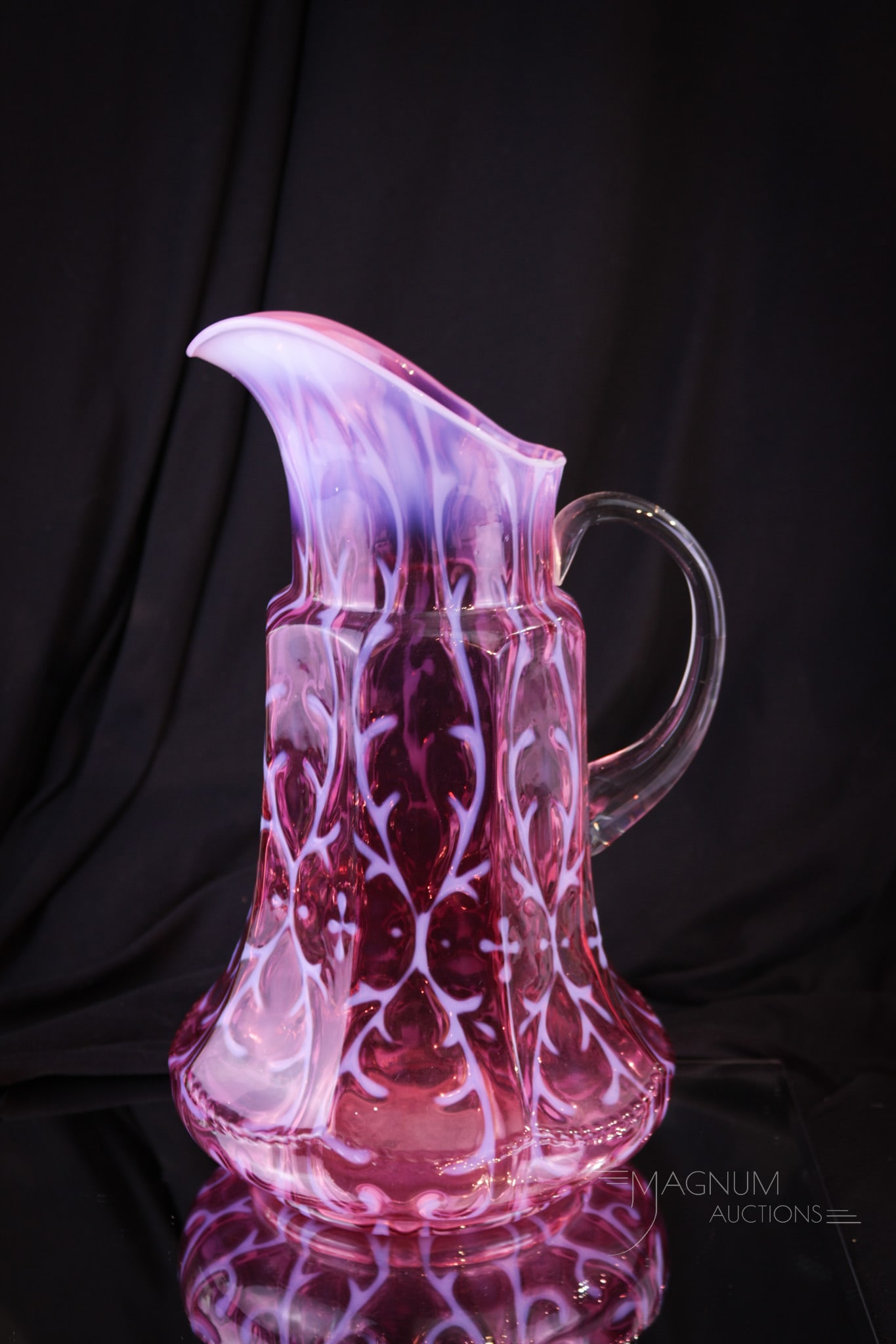 Northwood Cranberry Opalescent Spanish Lace Victorian Tankard Pitcher: Fine example of a beautiful Northwood water pitcher. This one is in the Spanish Lace pattern in the Nine-Panel mold. Lovely color and nice opal. Pitcher measures 11 1/2" tall. A faint hairline, possib
