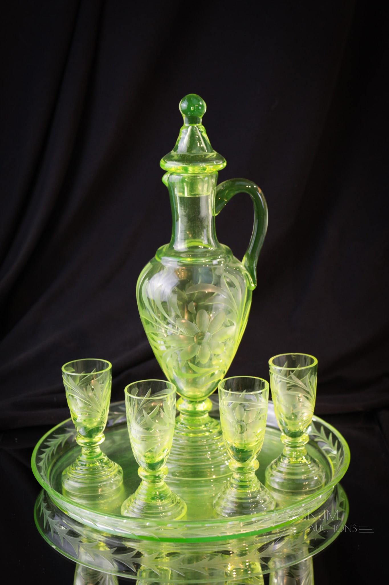 Vaseline Engraved Liquor Decanter Set: A finely cut engraved decanter liquor set complete with lid, four cordials, and a tray. This is a wonderful set and perfect for the Vasie lover in your life. This set measures 10 1/2" tall.