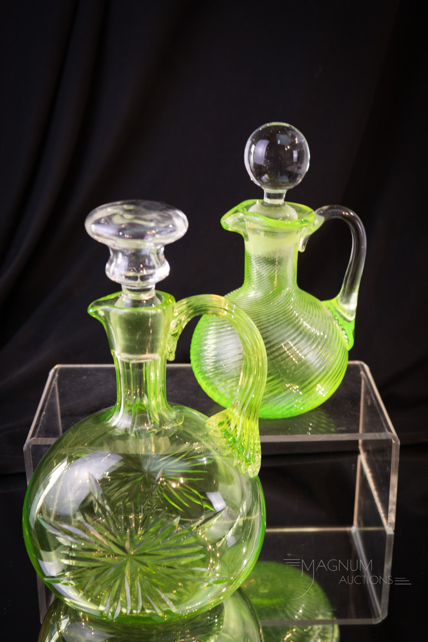 2 pc Lot Vaseline Victorian Glass Cruet & Decanter: Two piece lot of vaseline glass comprised by a spiral mold cruet along with a star cut decanter. Tallest measures 8".
