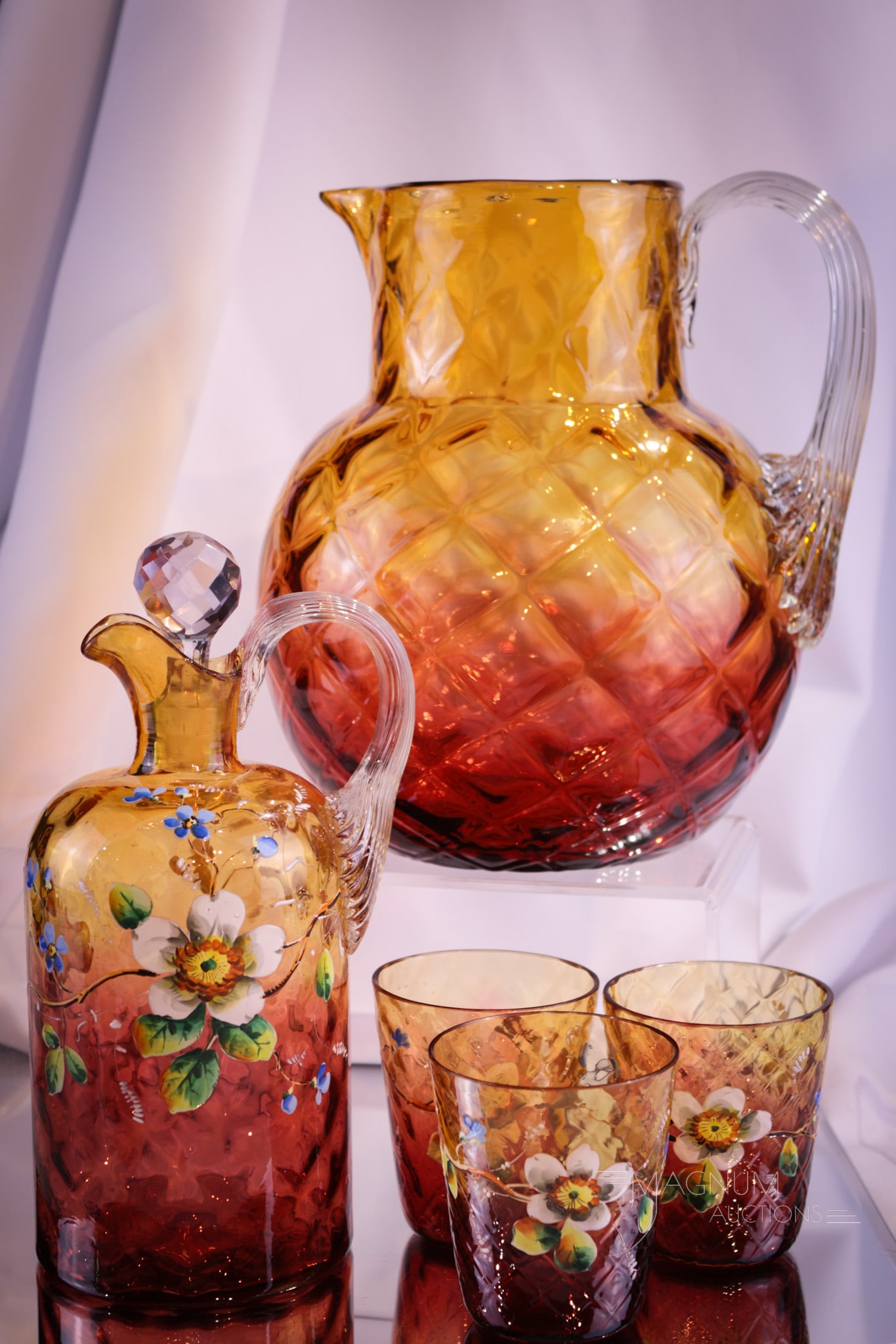5 pc Lot Harrach Amberina Enameled & More Victorian Glass: Five selection in amberina Victorian glass. This is actually reverse amberina with the amber being at the top. Each piece is externally diamond quilt. In this lot is a water pitcher and a decanter wit