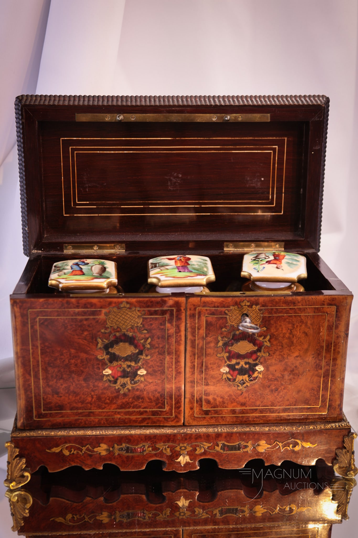 English Late Georgian Inlaid Tea Caddy: Beautiful Engish late Georgian tea caddy complete with three porcelain vessels. Caddy is embellished with bronze mounts and retians the key. Caddy measures 6 3/4" tall, 8 1/2" wide. Restoration is not