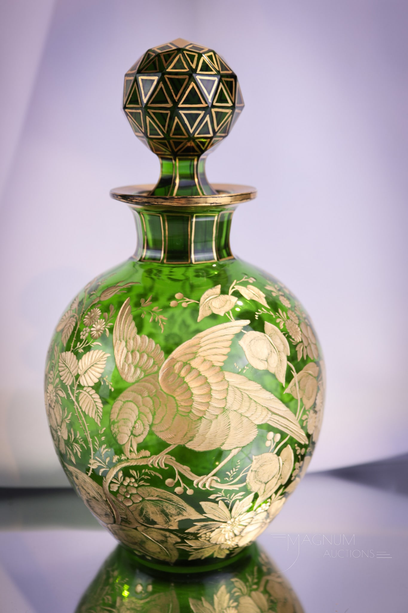 Moser Green Engraved Glass Cologne Bottle: Fine Moser green glass cologne bottle with all-over engraved cutting and gilt decoration. Bottle is complete with matching stopper. Piece measures 7" tall.